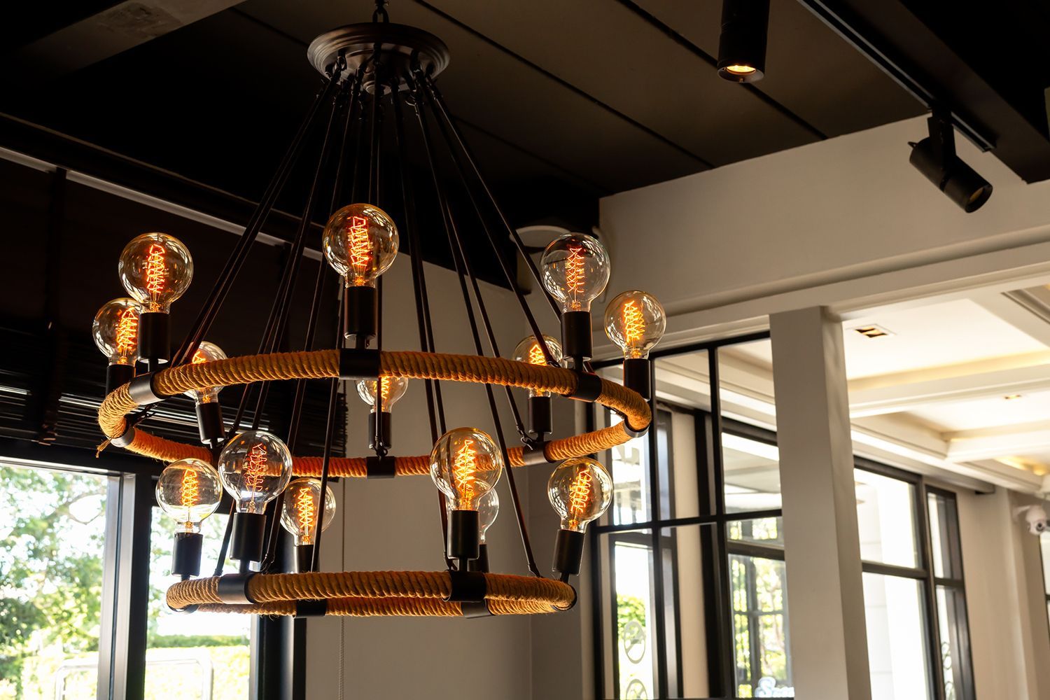 Decorative chandelier with Edison bulbs in a room with black and white accents. Decorative chandelier with Edison bulbs in a room with black and white accents.