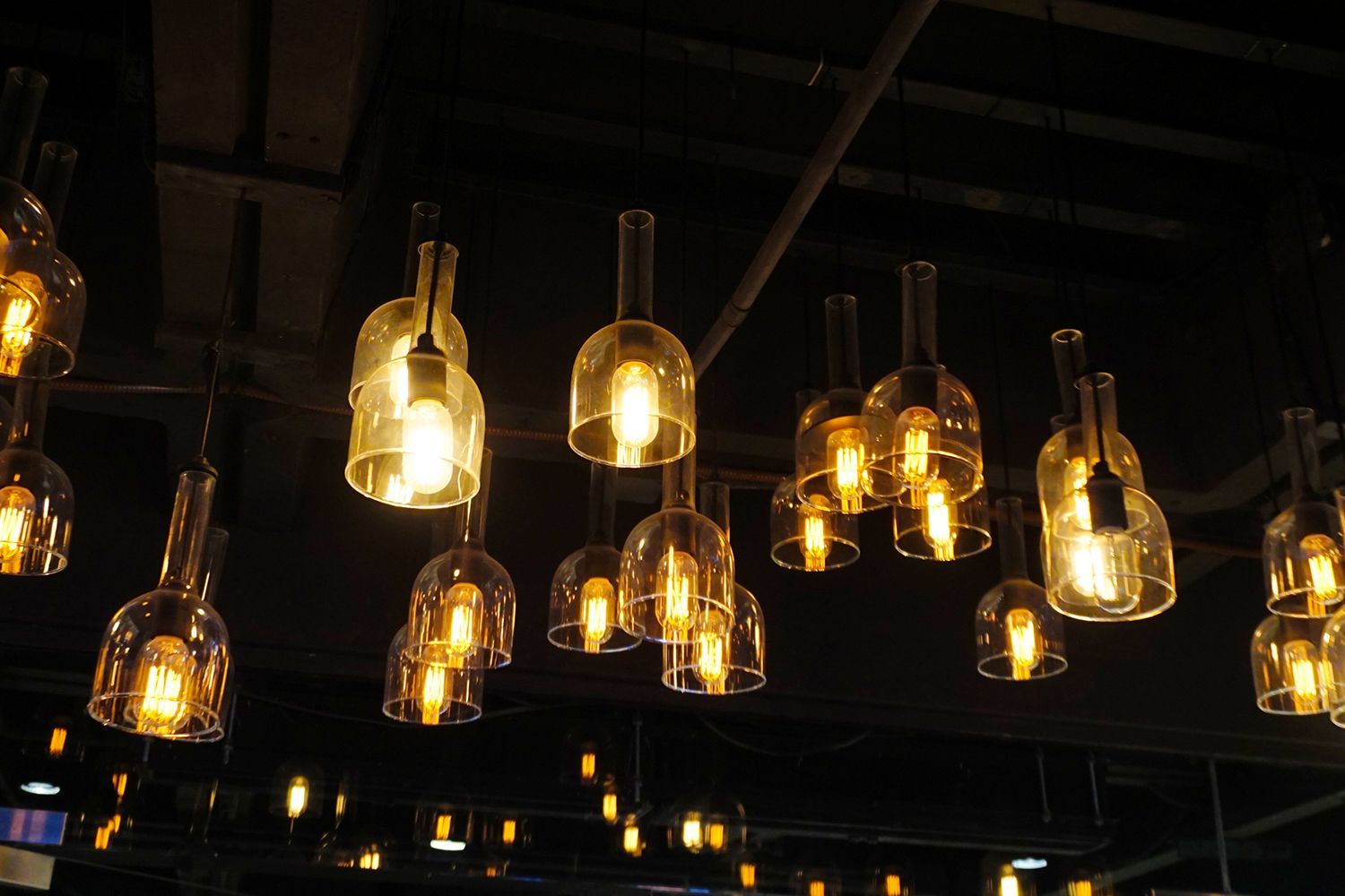 Ceiling lights made from glass bottles with glowing warm lightbulbs. Ceiling lights made from glass bottles with glowing warm lightbulbs.