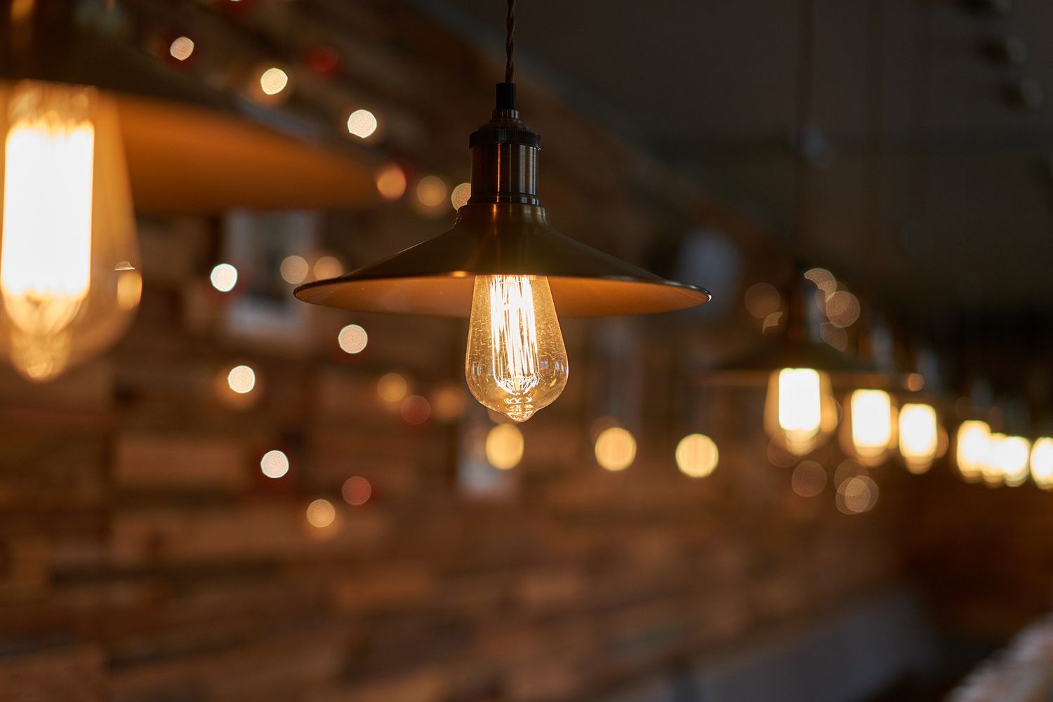 Vintage light fixtures hanging from a ceiling, with warm glowing bulbs. Vintage light fixtures hanging from a ceiling, with warm glowing bulbs.