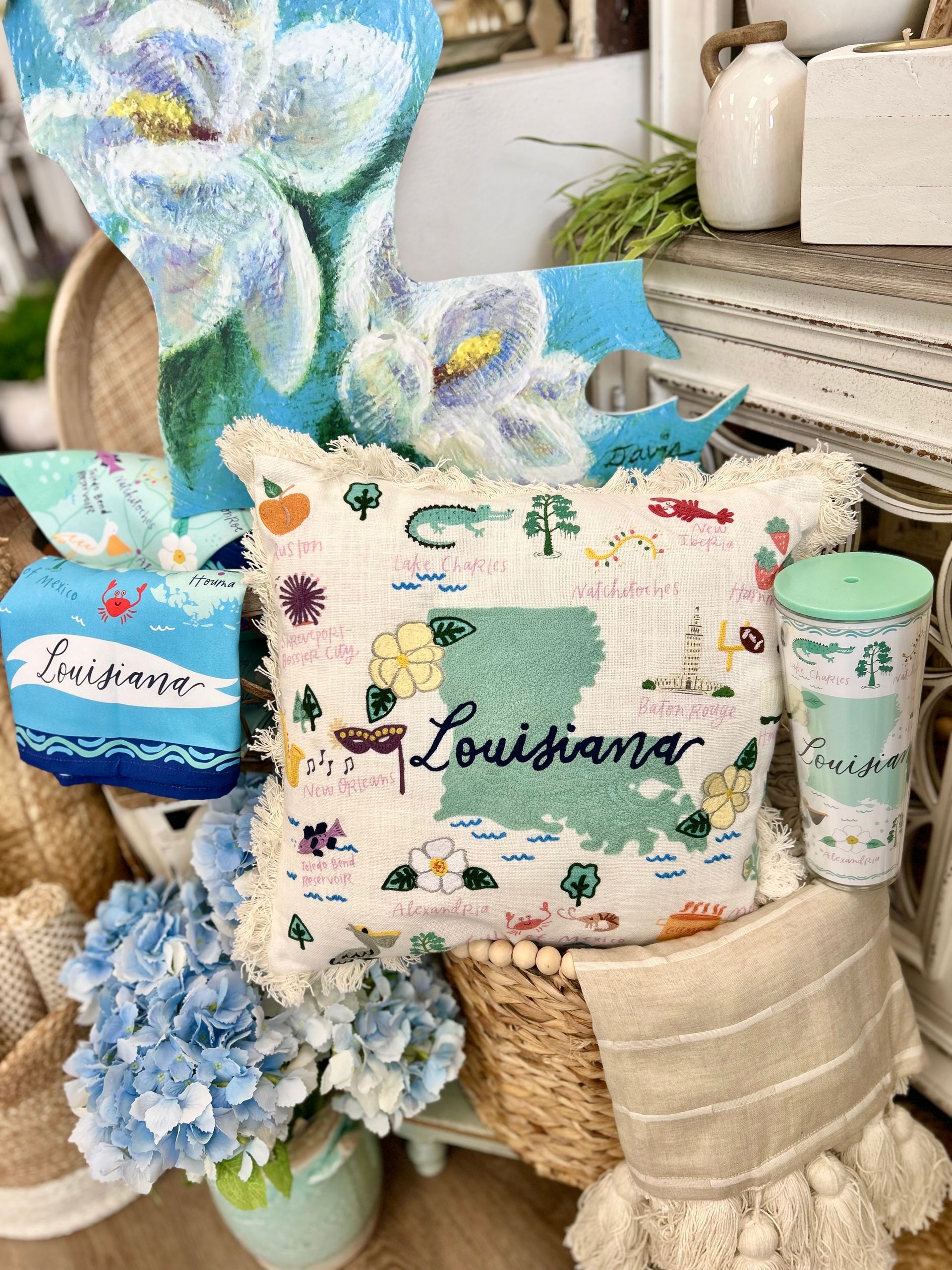 A pillow with the state of louisiana on it is sitting on top of a wicker chair.