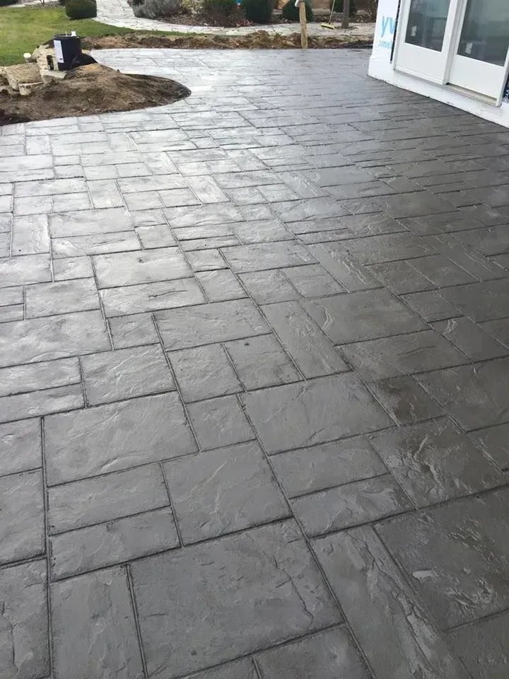Gray stamped concrete patio with irregular rectangular pattern.