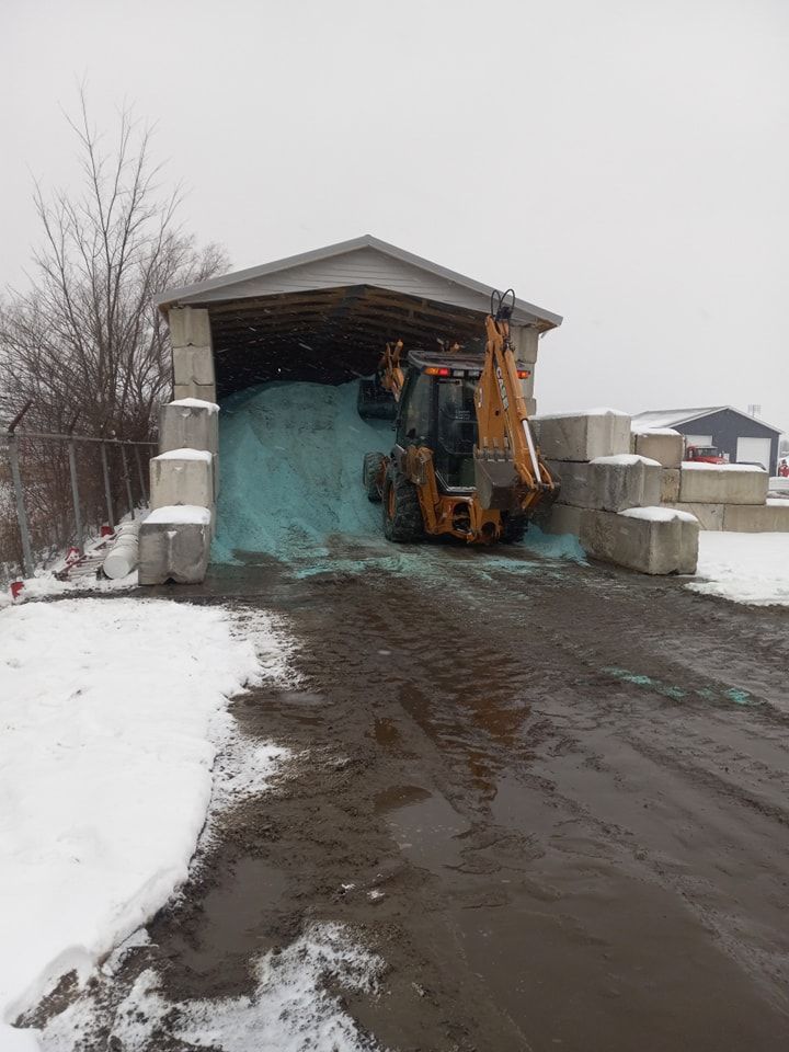 A large pile of snow is being loaded into a truck.