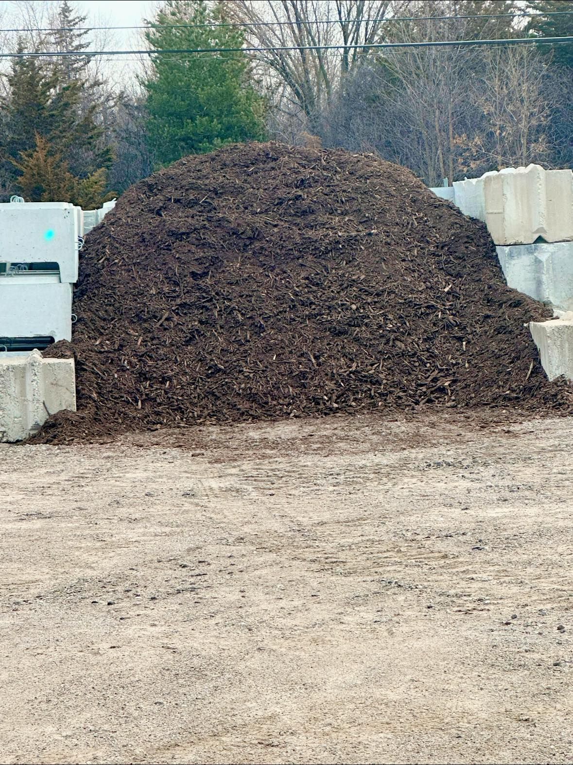 There is a large pile of dirt in the middle of a dirt field.