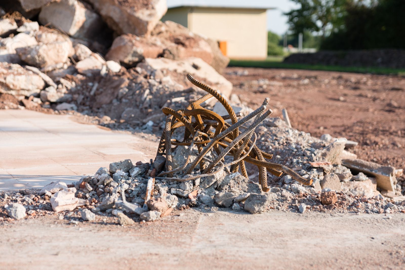 Pile of rubble with exposed rusty rebar; a construction or demolition site.