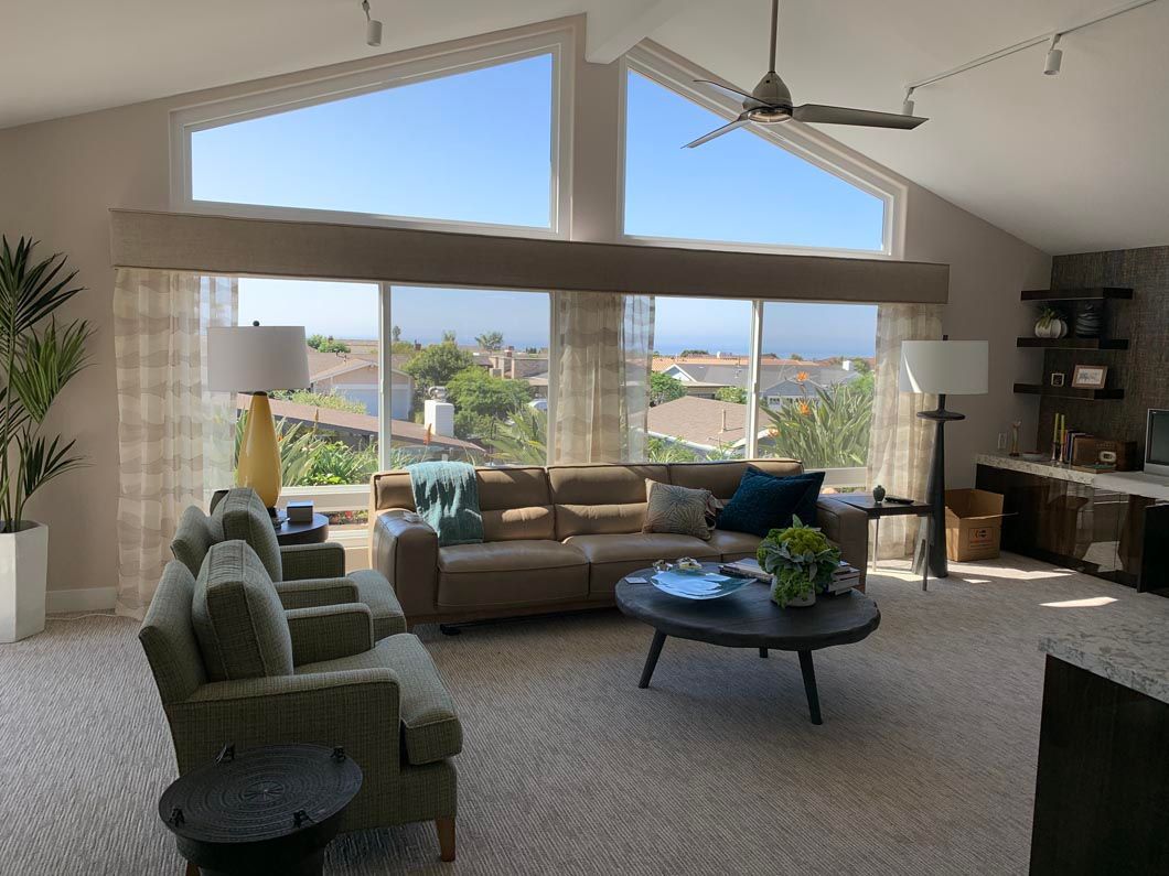 A living room with a vaulted ceiling and a couch and chairs