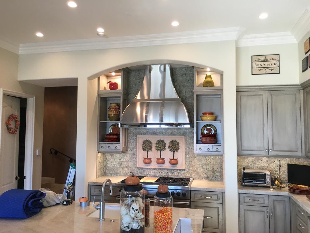 A kitchen with stainless steel appliances and gray cabinets