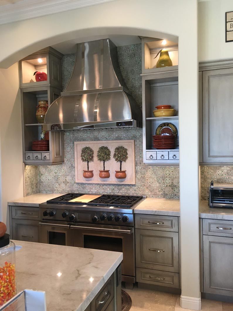 A kitchen with stainless steel appliances and a painting on the wall