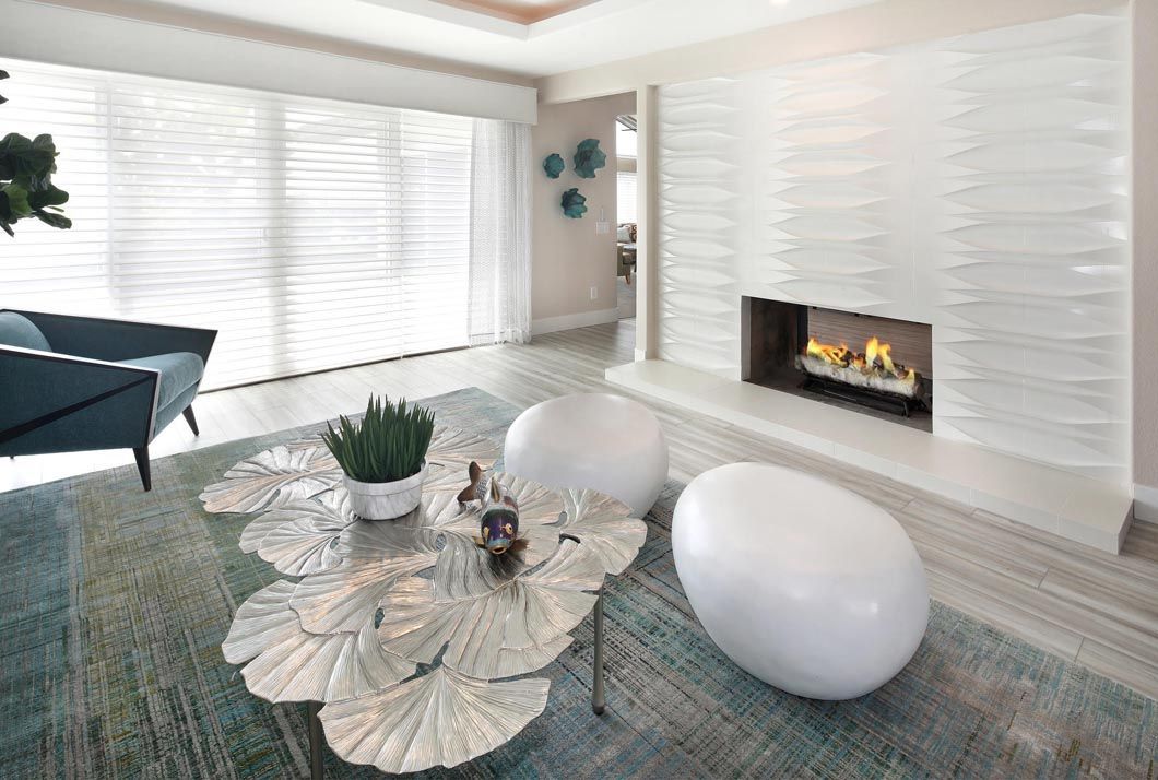 A living room with a fireplace , coffee table , and chairs.