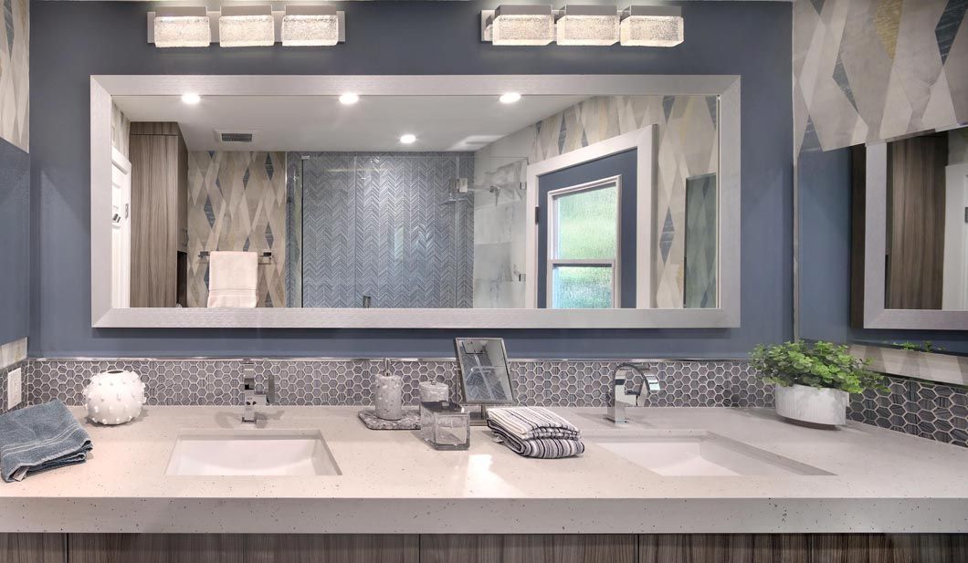 A bathroom with two sinks and a large mirror.