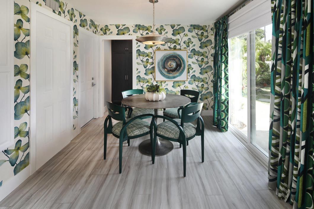 A dining room with a table and chairs and green curtains