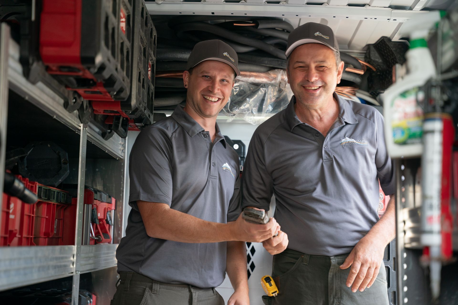 A group of people standing in front of a triumph heating and air conditioning van.