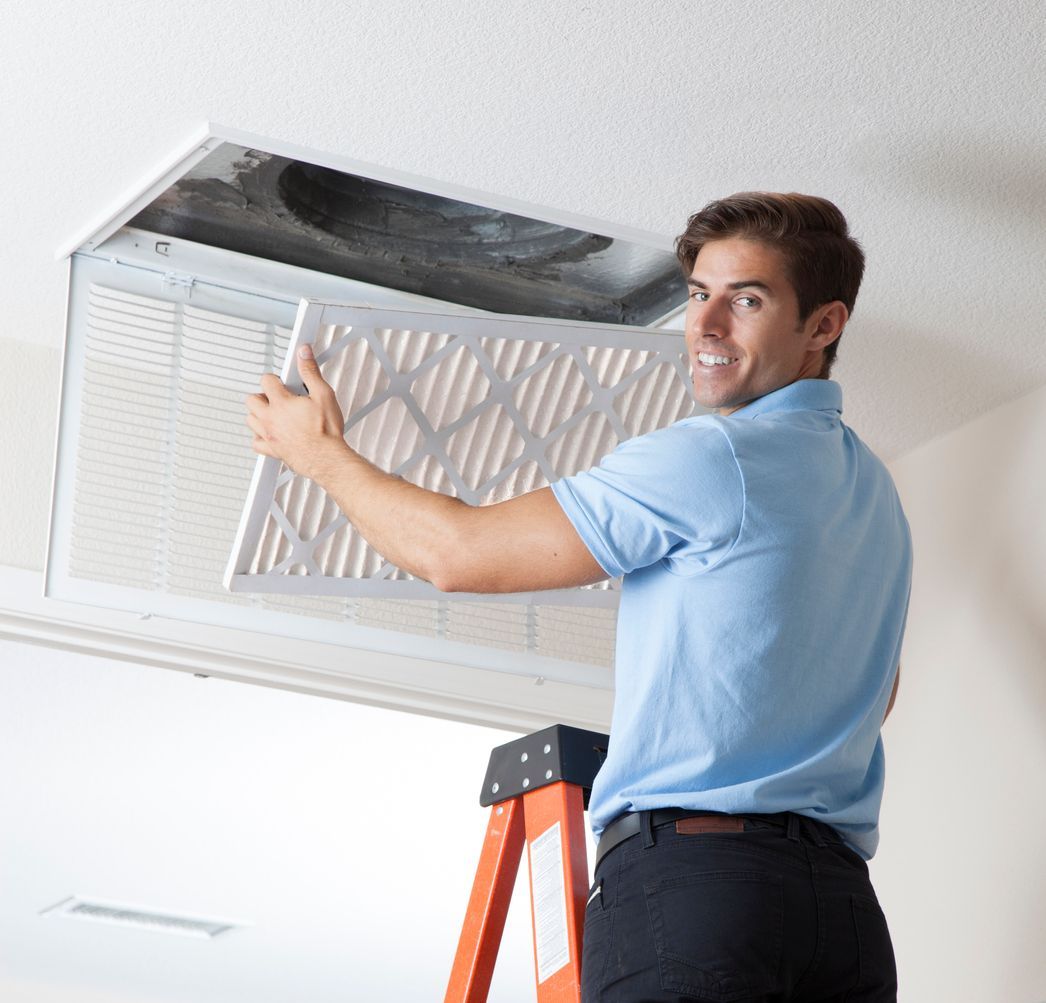 Technician installing a home air purifier in a residential HVAC system for improved indoor air.