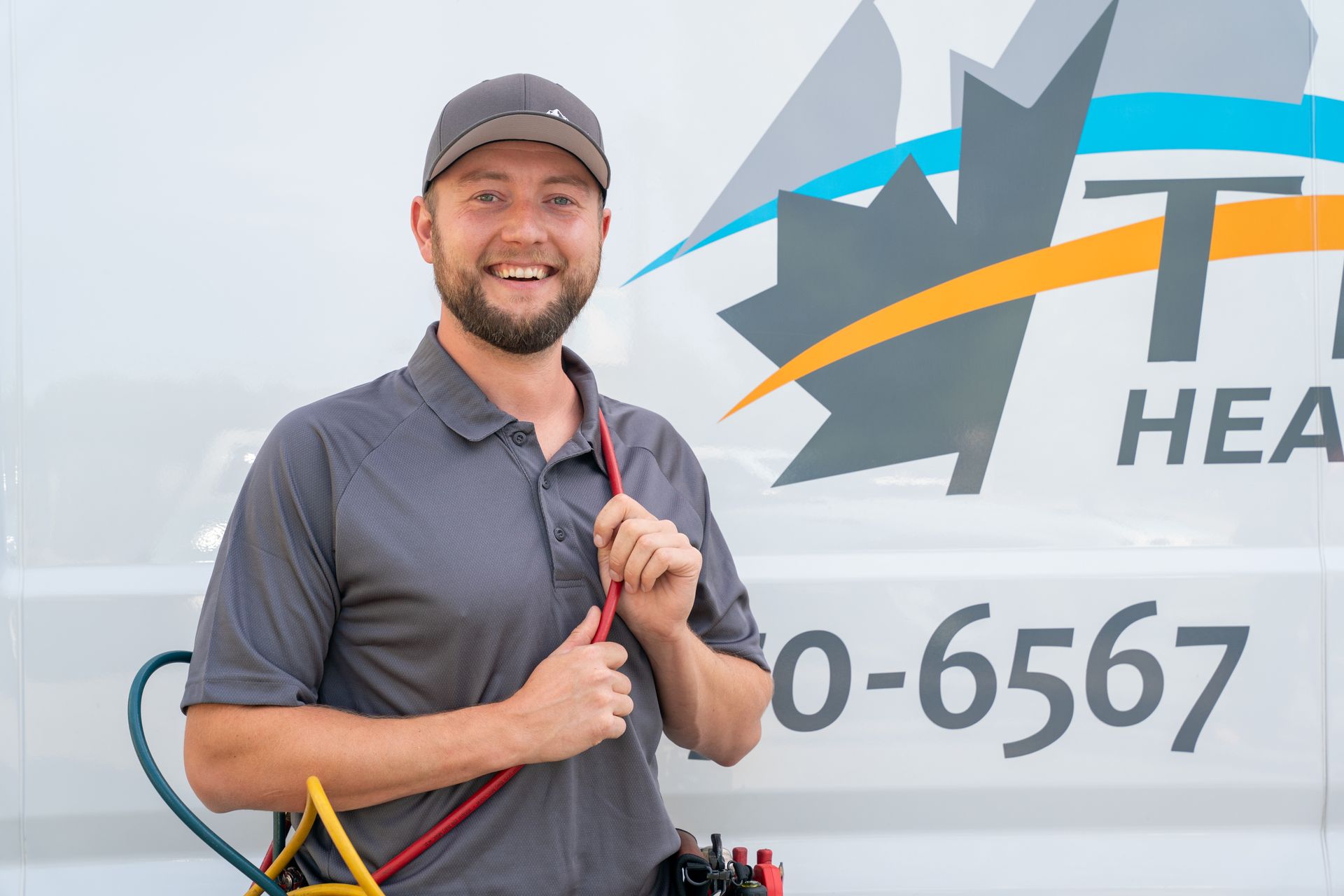 A man with a beard is smiling while working on a computer.