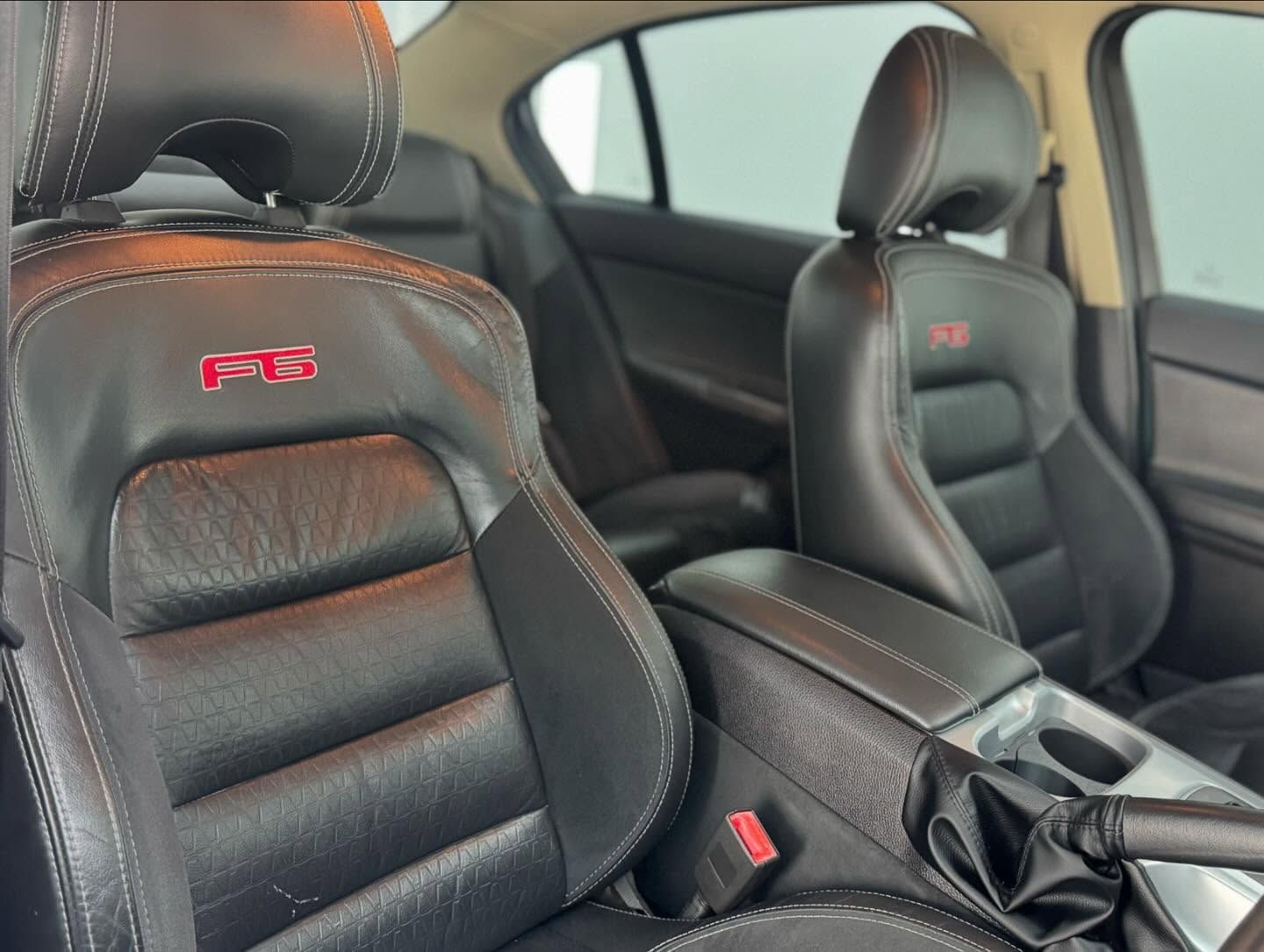 The Interior of a Car With Black Leather Seats and a Red Emblem on the Seat — Bathurst Detailing Studio in Dubbo, NSW