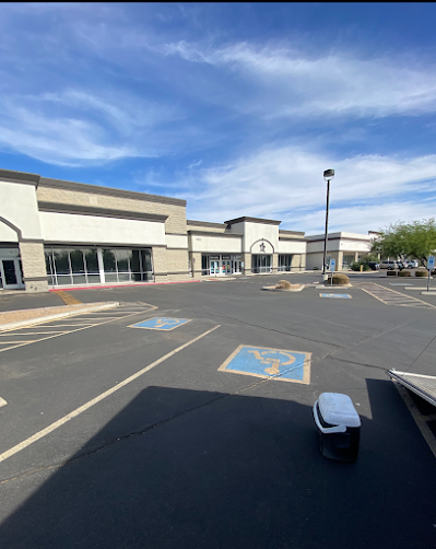 A parking lot in front of a building with a handicapped parking spot.