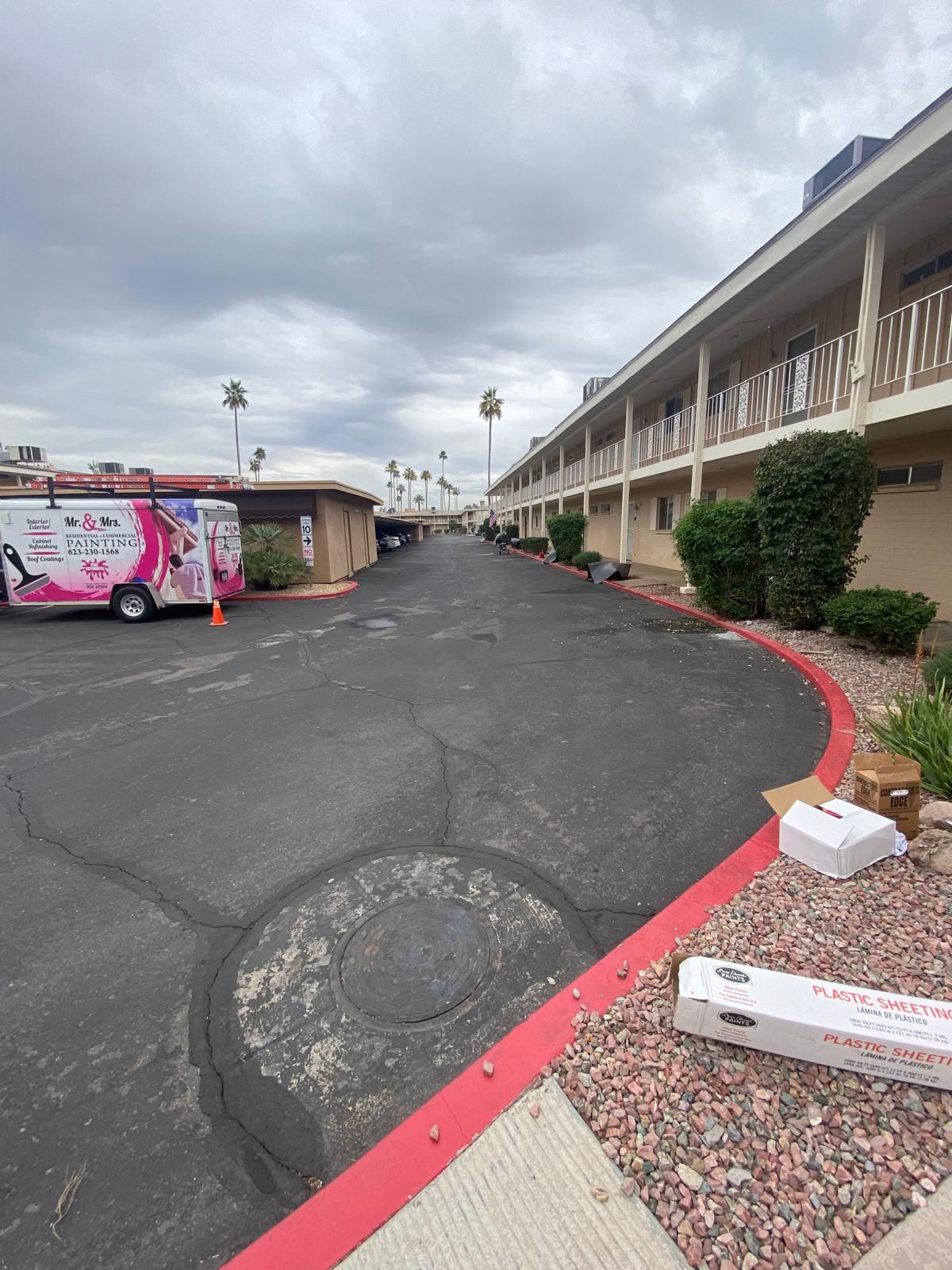 A white truck is parked on the side of the road in front of a building.