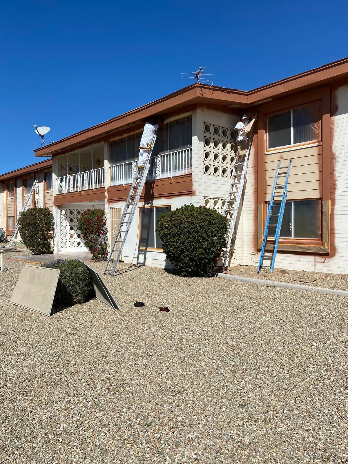 A man is painting a building with a ladder.