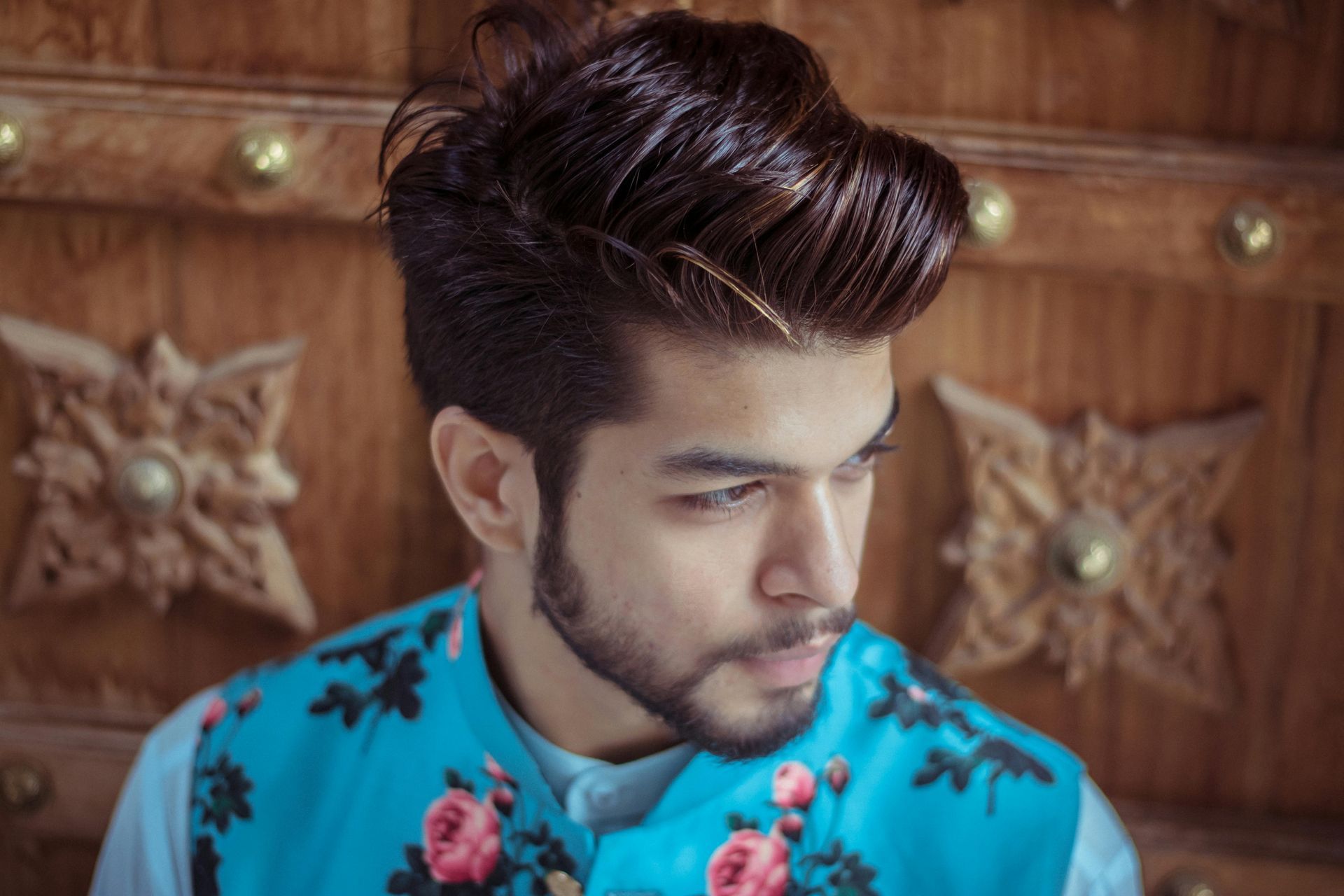 A young person with dark hair in a snowy field, wearing a scarf, looking towards the camera.