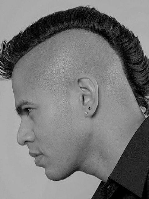 A black and white photo of a man with a mohawk