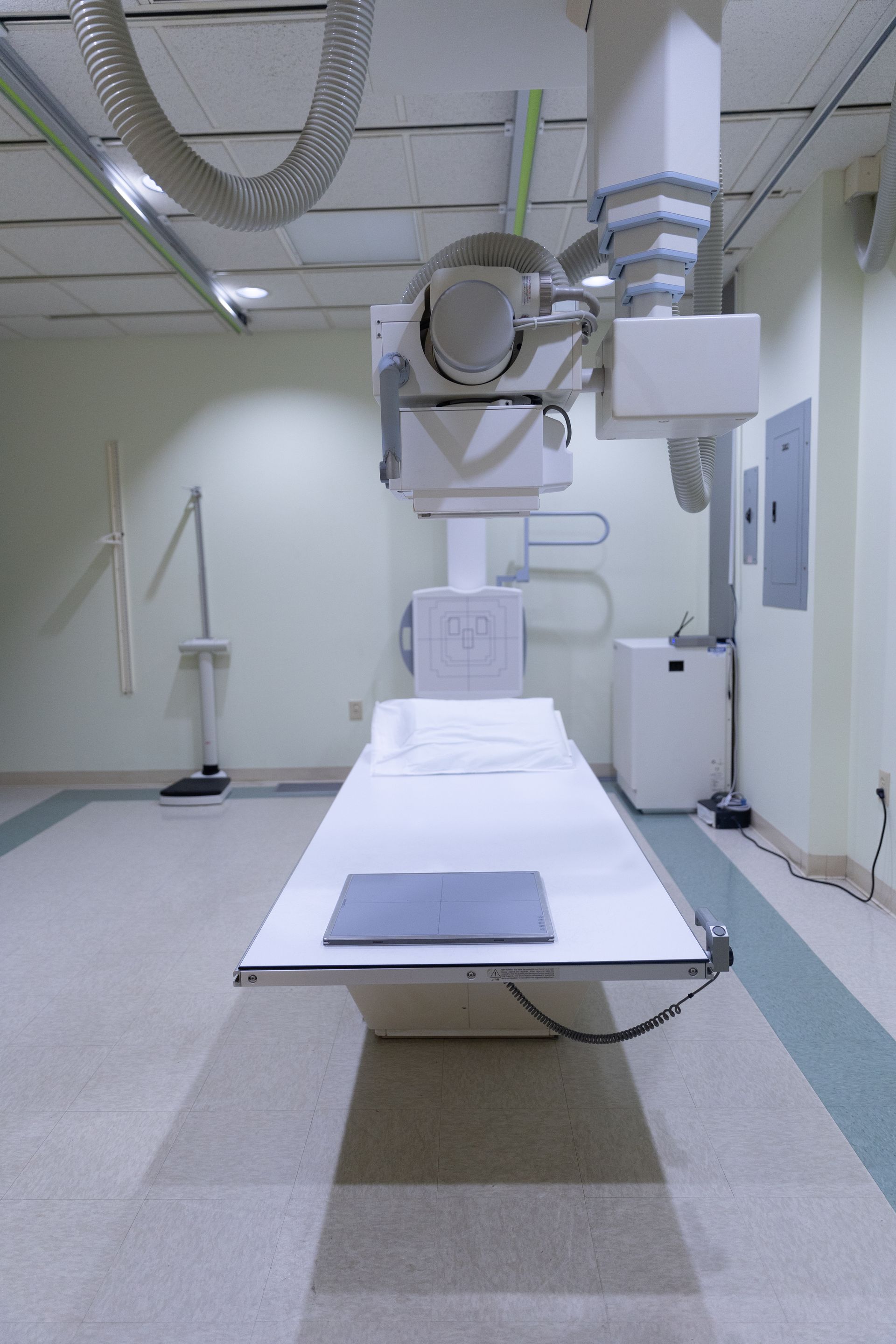 A doctor 's office with a bed , chairs , and a light box.