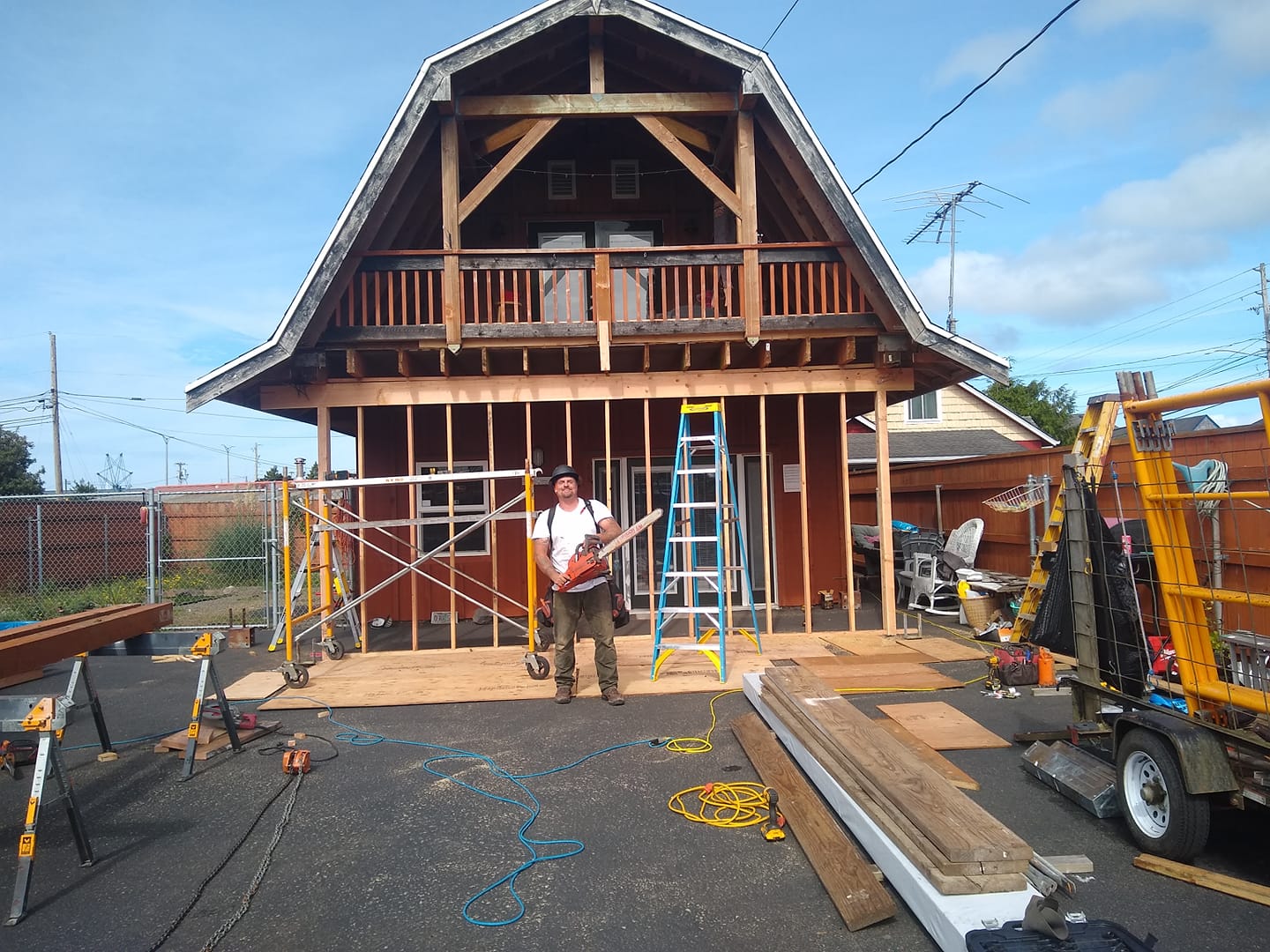 A man is standing in front of a house that is being built