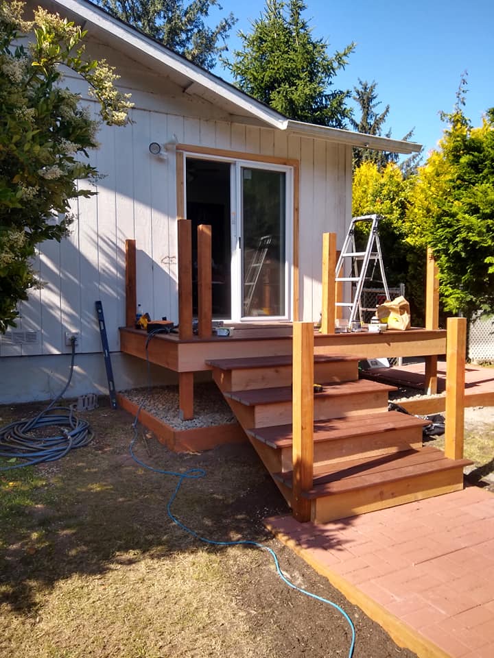 A wooden deck is being built on the side of a house.