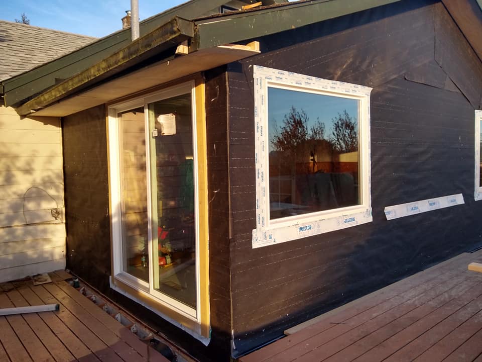 A house with a sliding glass door and a window on the side.