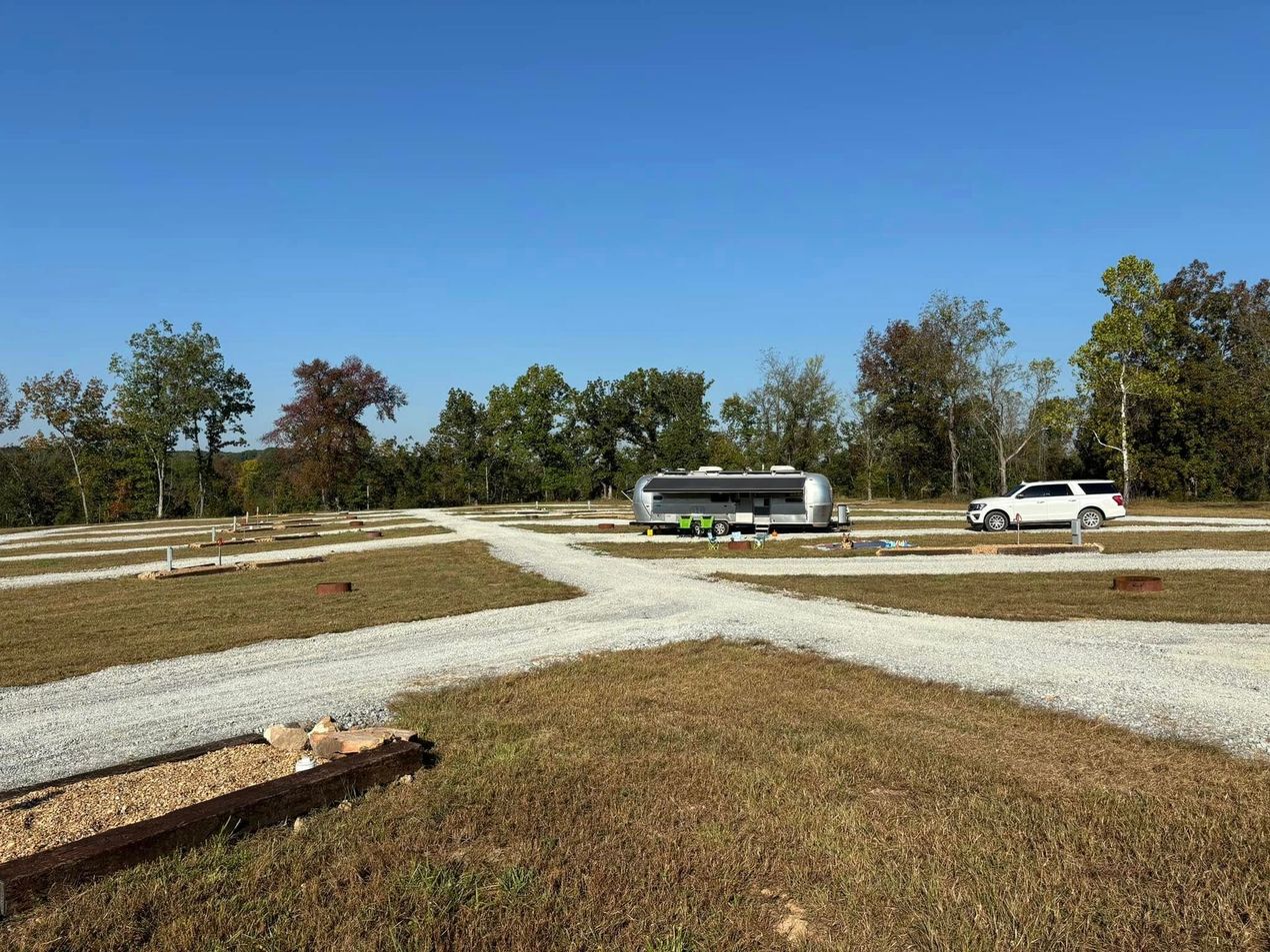 A rv is parked in the middle of a dirt road.