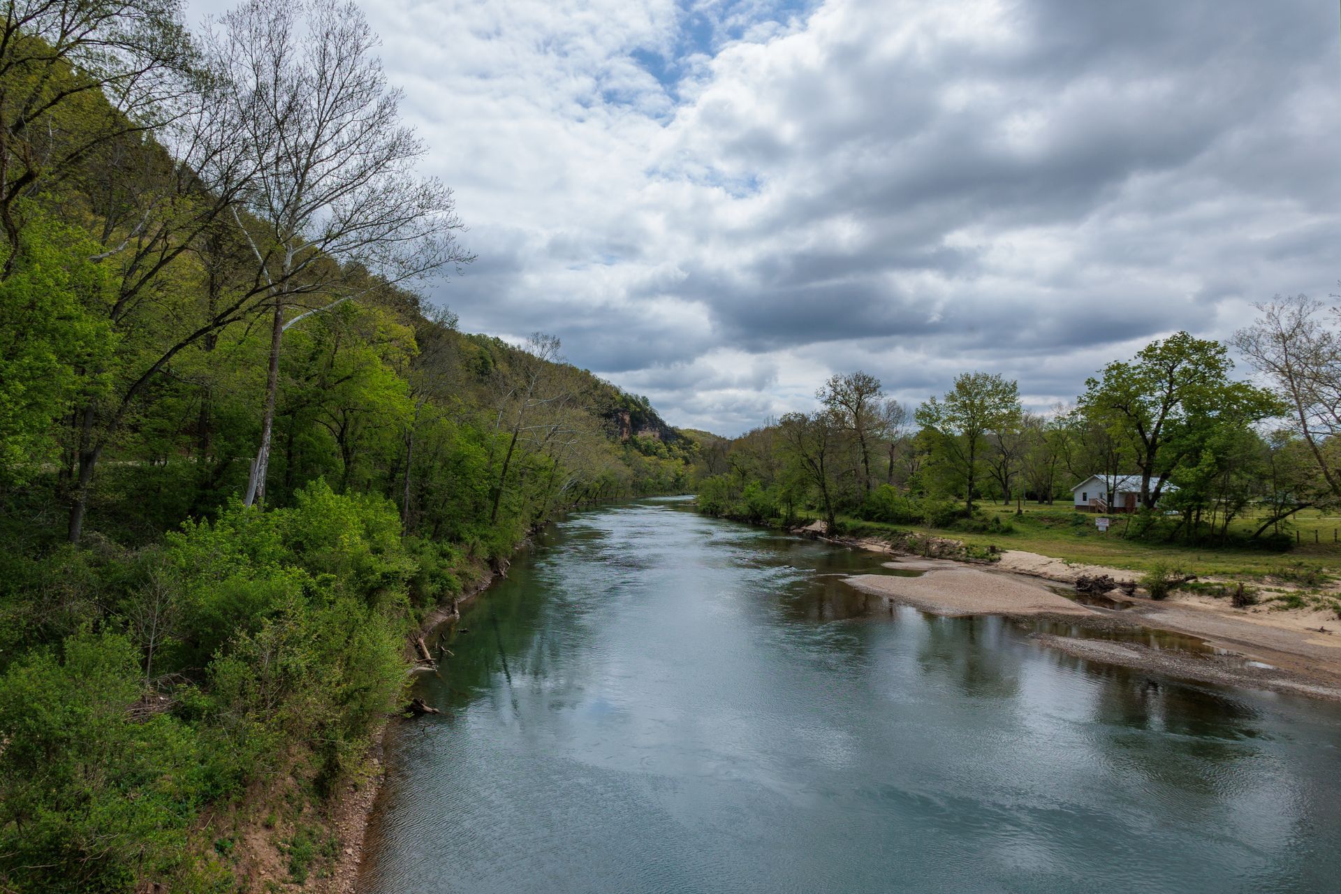 A river surrounded by trees on a cloudy day