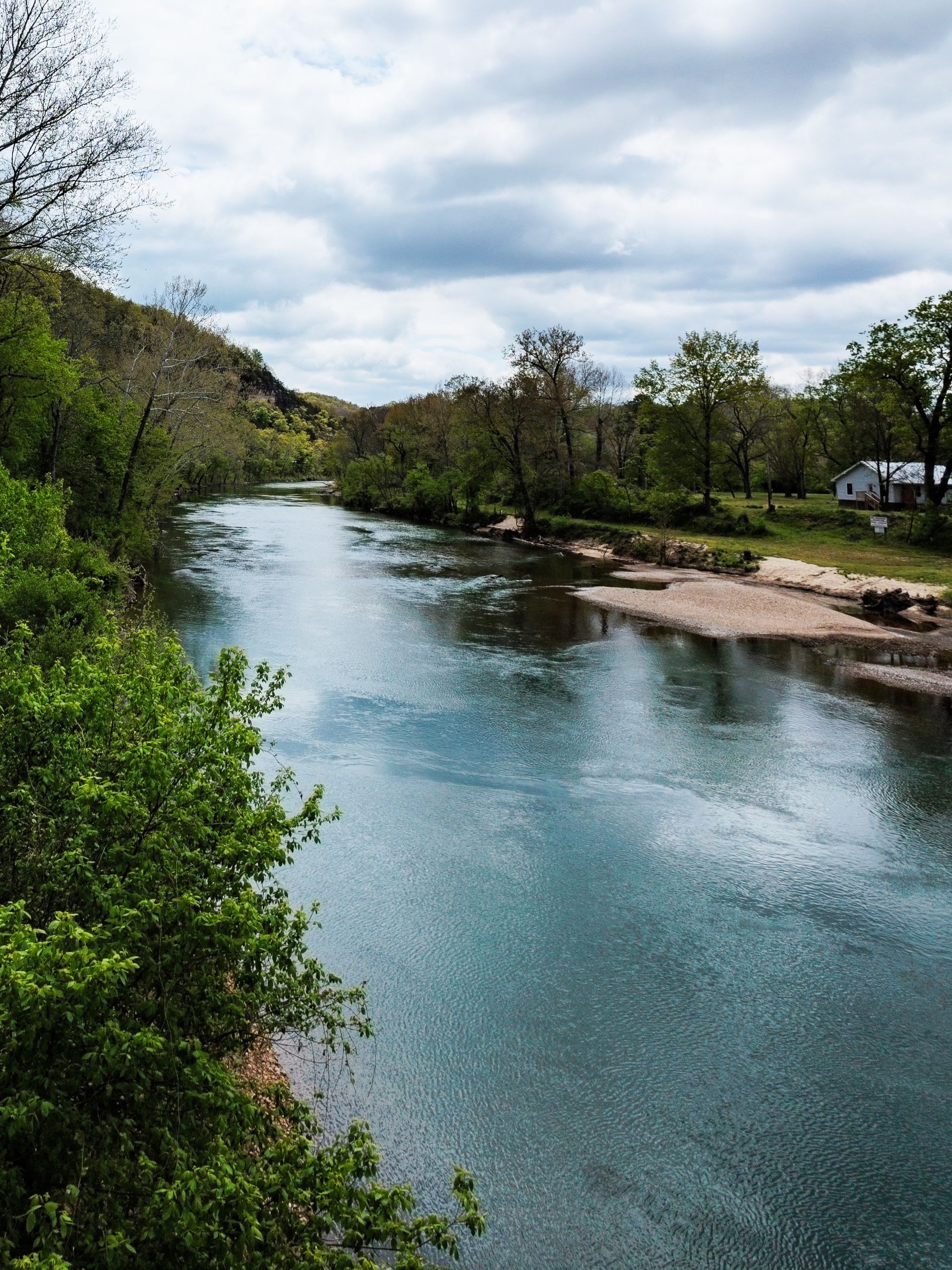 A river surrounded by trees on a cloudy day