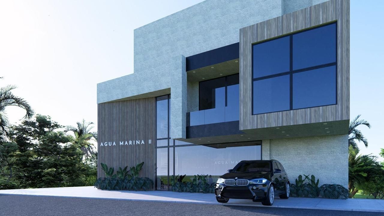 Resort hotelero de color blanco con vistas a la playa y al océano con palmeras bajo un cielo azul.