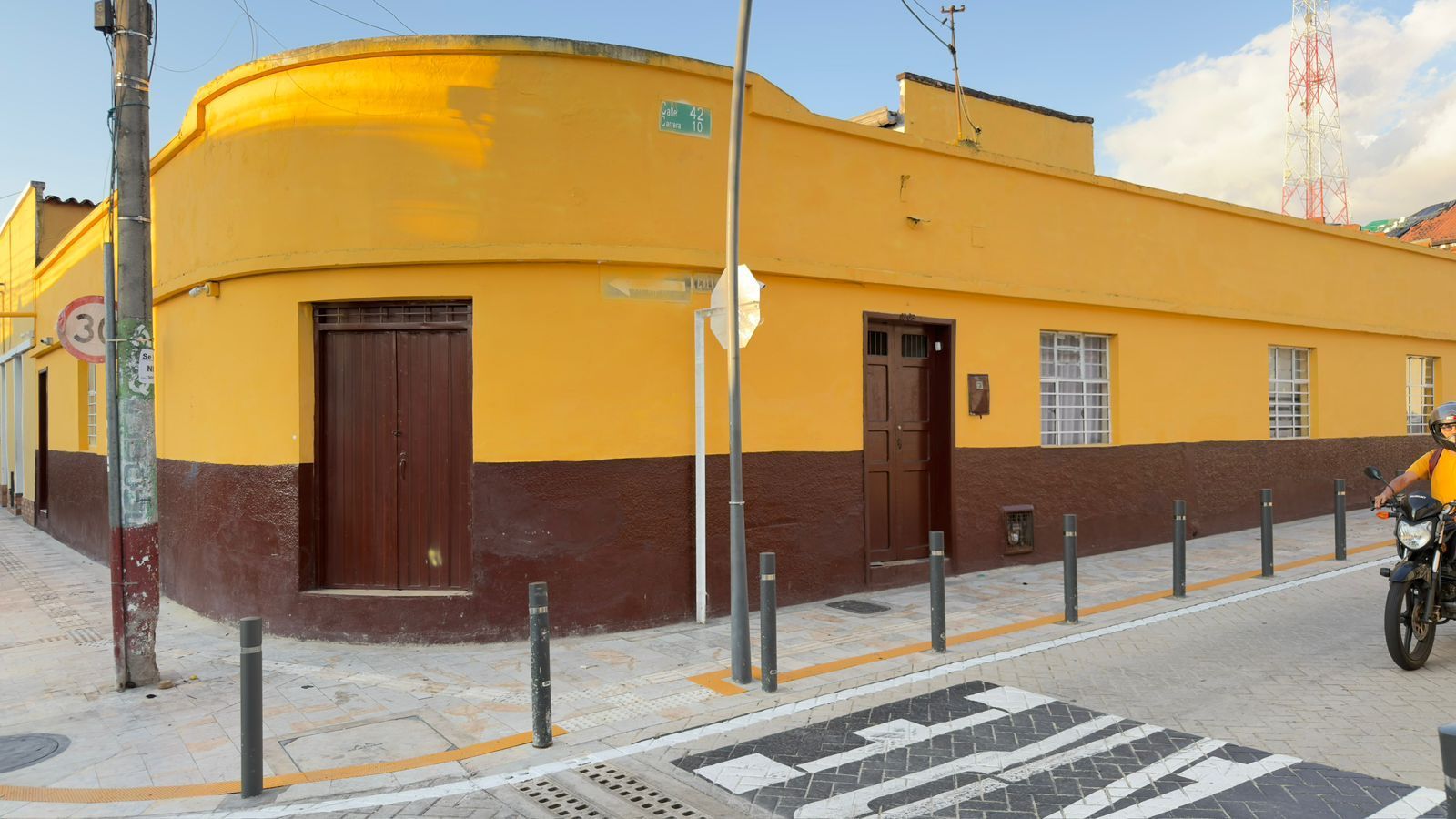 Un edificio amarillo con detalles marrones en una esquina, capturado en una toma panorámica