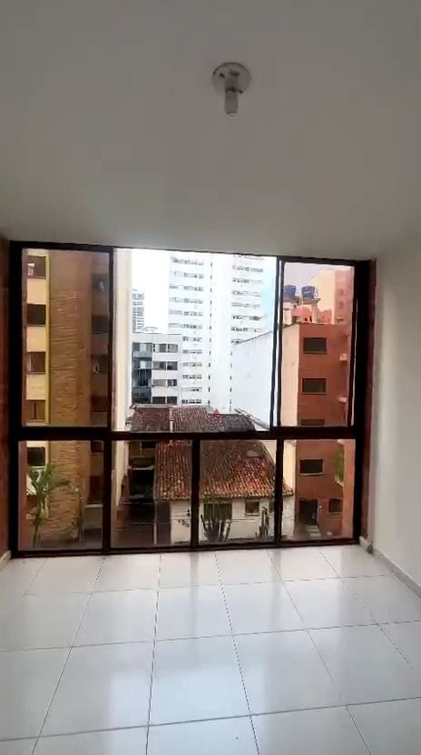 Sala de estar moderna: sofá gris, piso de madera, mesa de comedor redonda con sillas blancas, vista al dormitorio.