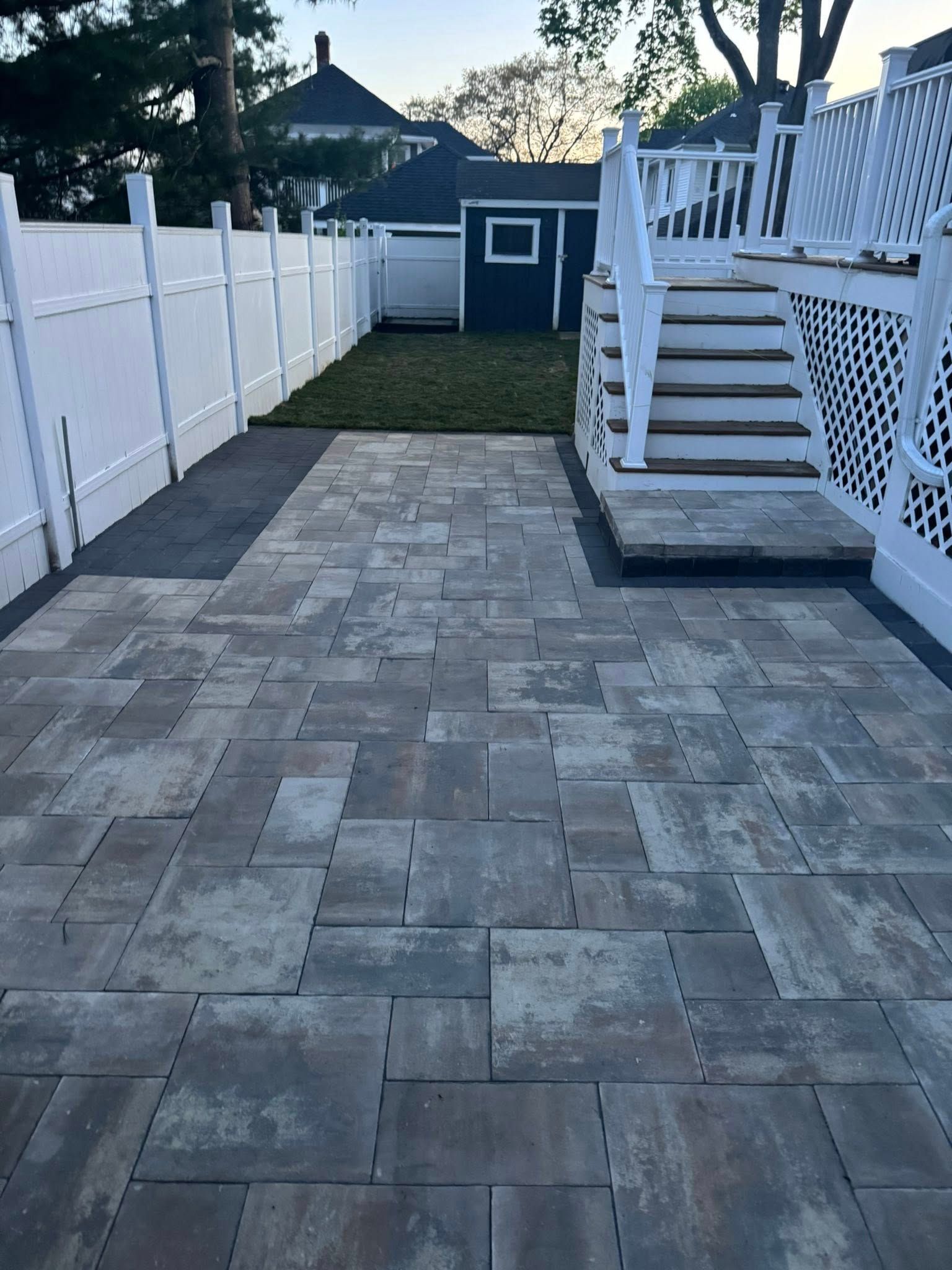 Swimming pool with waterfall, hot tub, and lush landscaping. Blue tile, stone accents, sunny.
