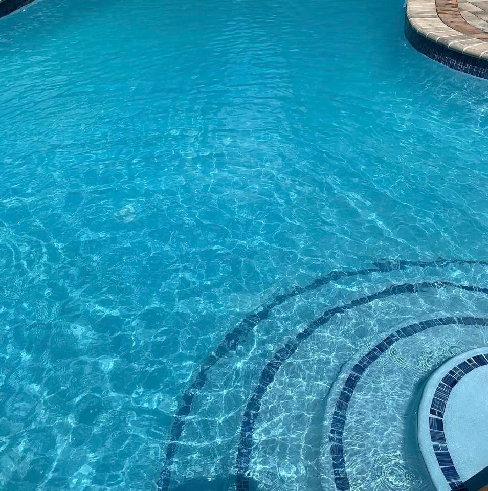 Clear blue swimming pool with steps.