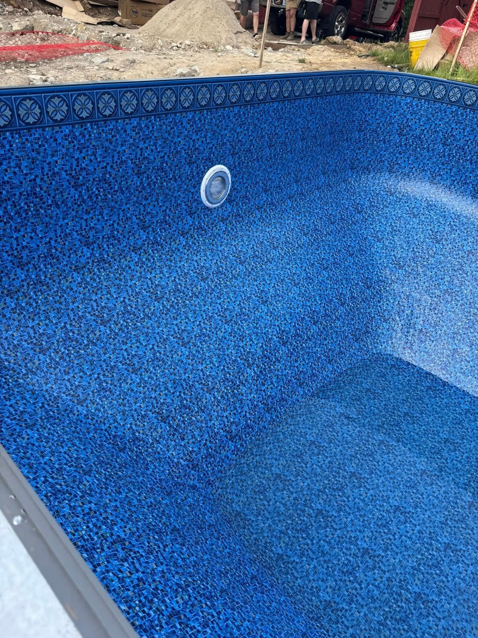 Blue patterned swimming pool with a light fixture.