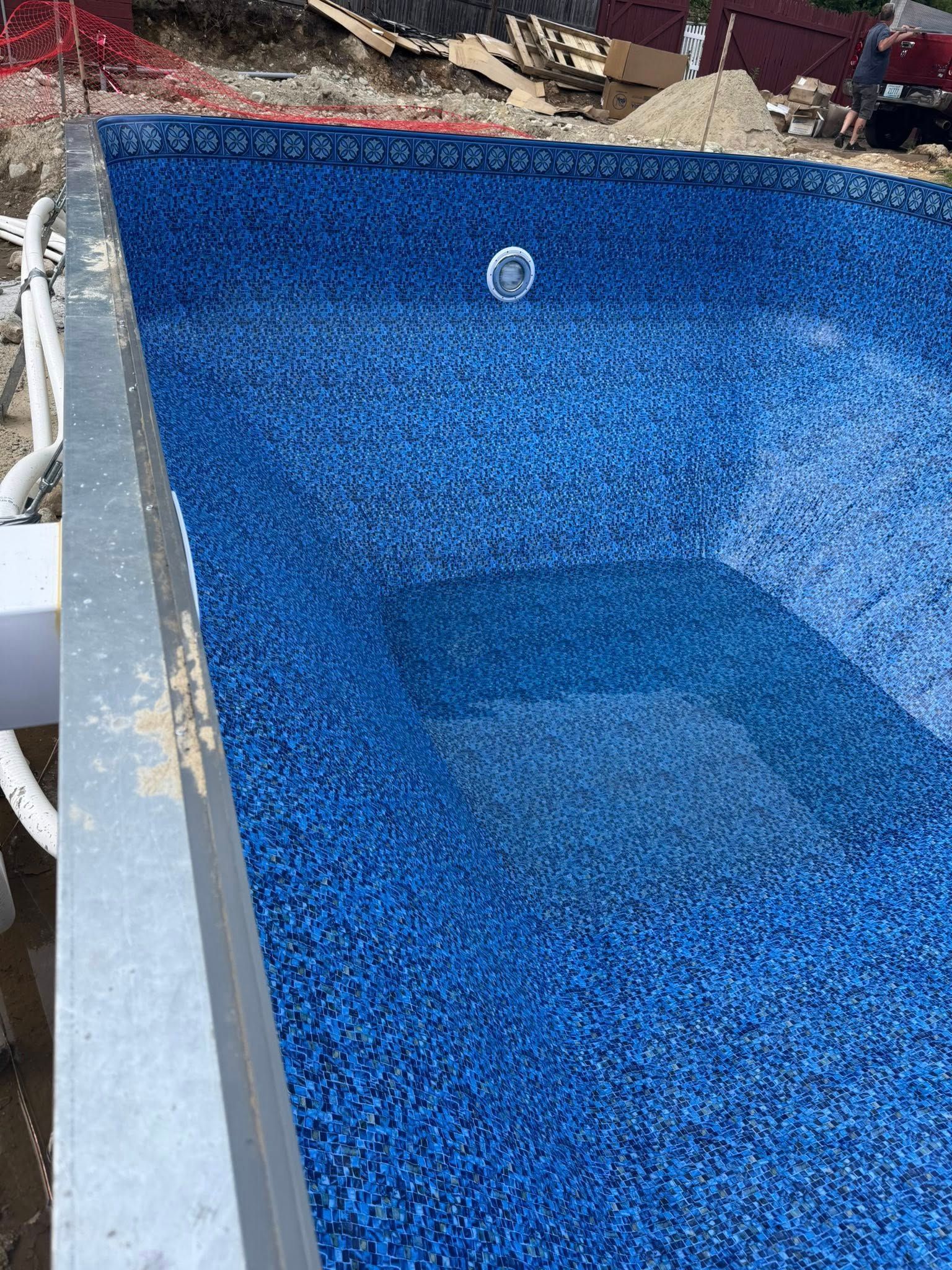 Blue tiled swimming pool under construction.