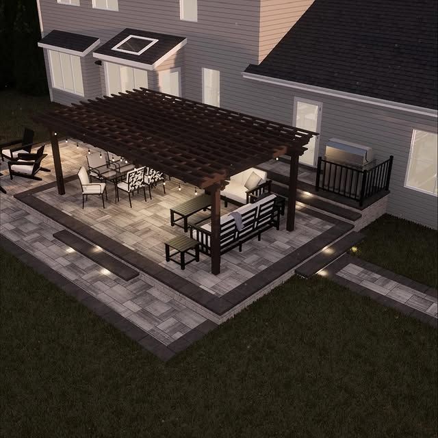 Patio with pergola, furniture, and grill. Dark wood, gray pavers, and outdoor lighting.