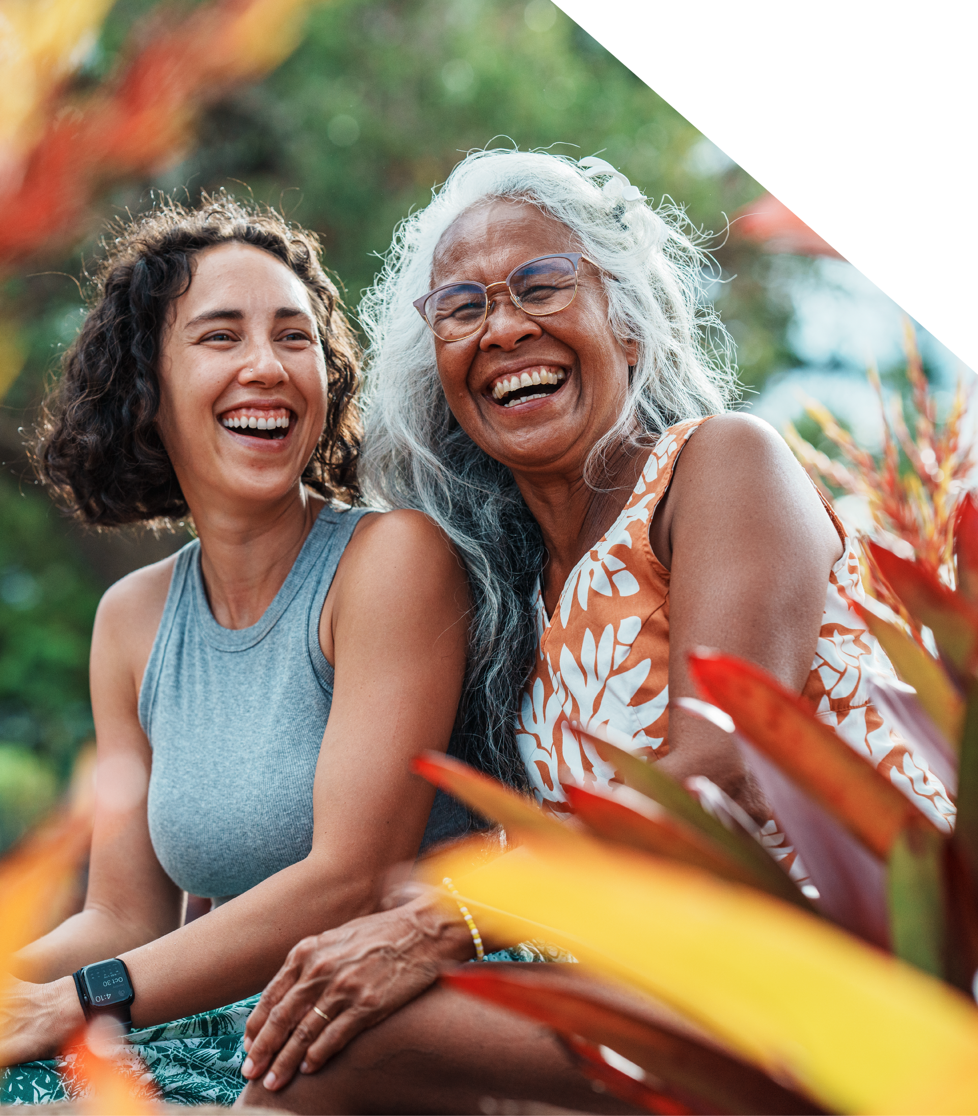 Two women are sitting next to each other and smiling.