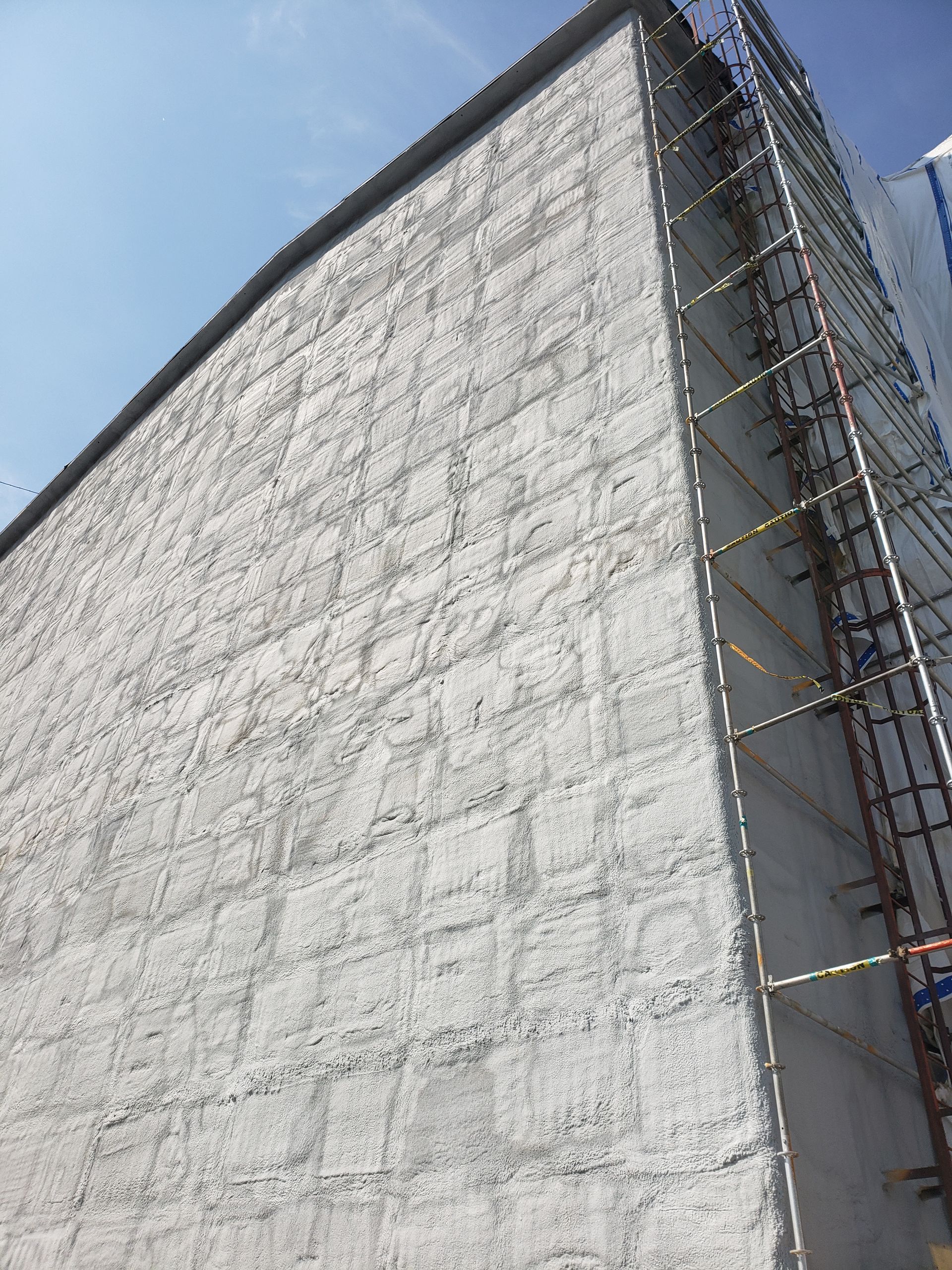 A large white building with scaffolding on the side of it.