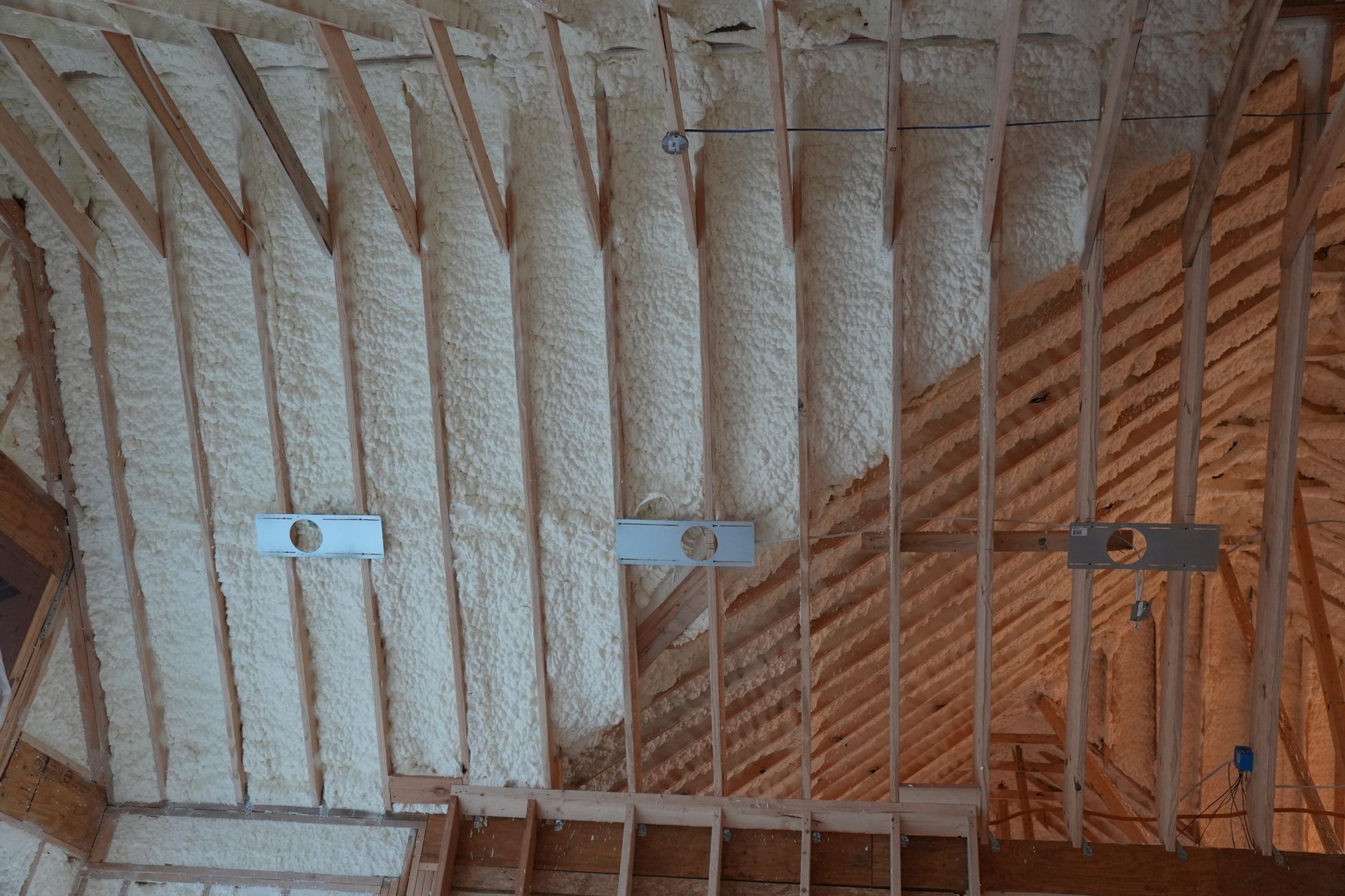 Open-cell spray foam insulation covering an attic roof deck in a Chattanooga home, installed by Foam