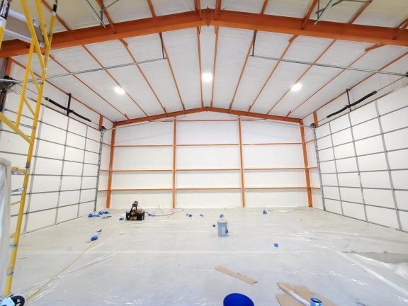 A large empty warehouse with white walls and orange trim