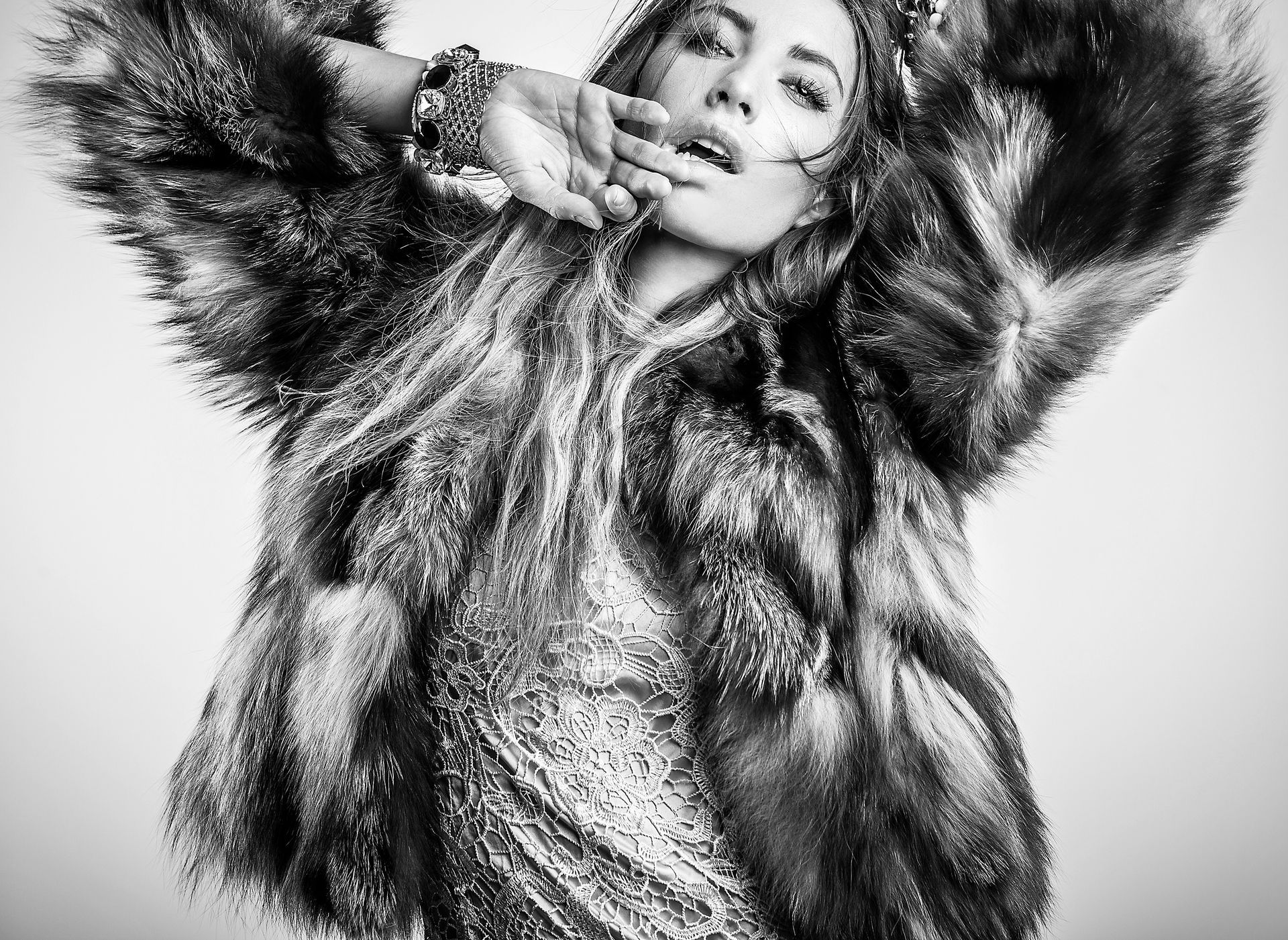 A black and white photo of a woman wearing a fur coat.