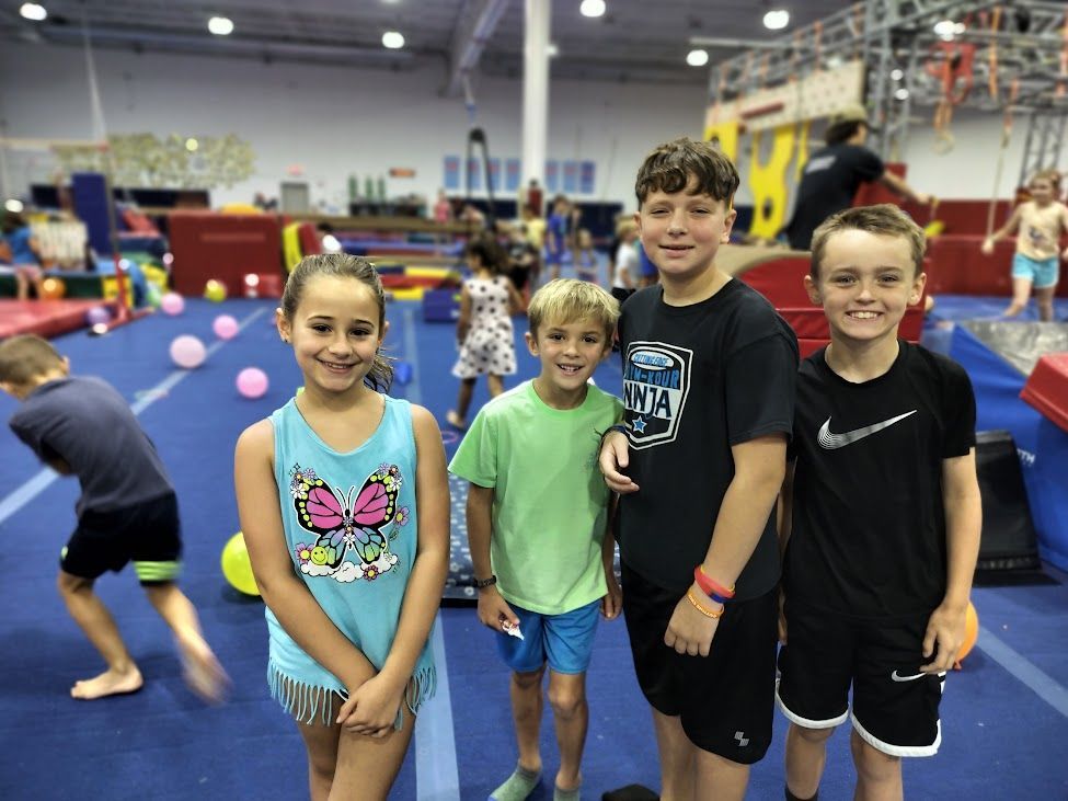 A group of children are posing for a picture in a gym.