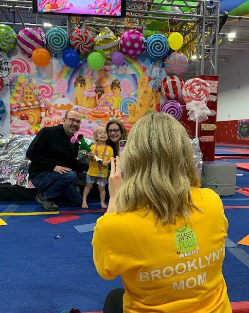 A woman in a yellow shirt is taking a picture of a family.