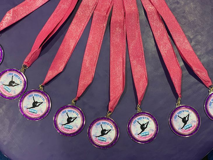 A bunch of medals with pink ribbons on them
