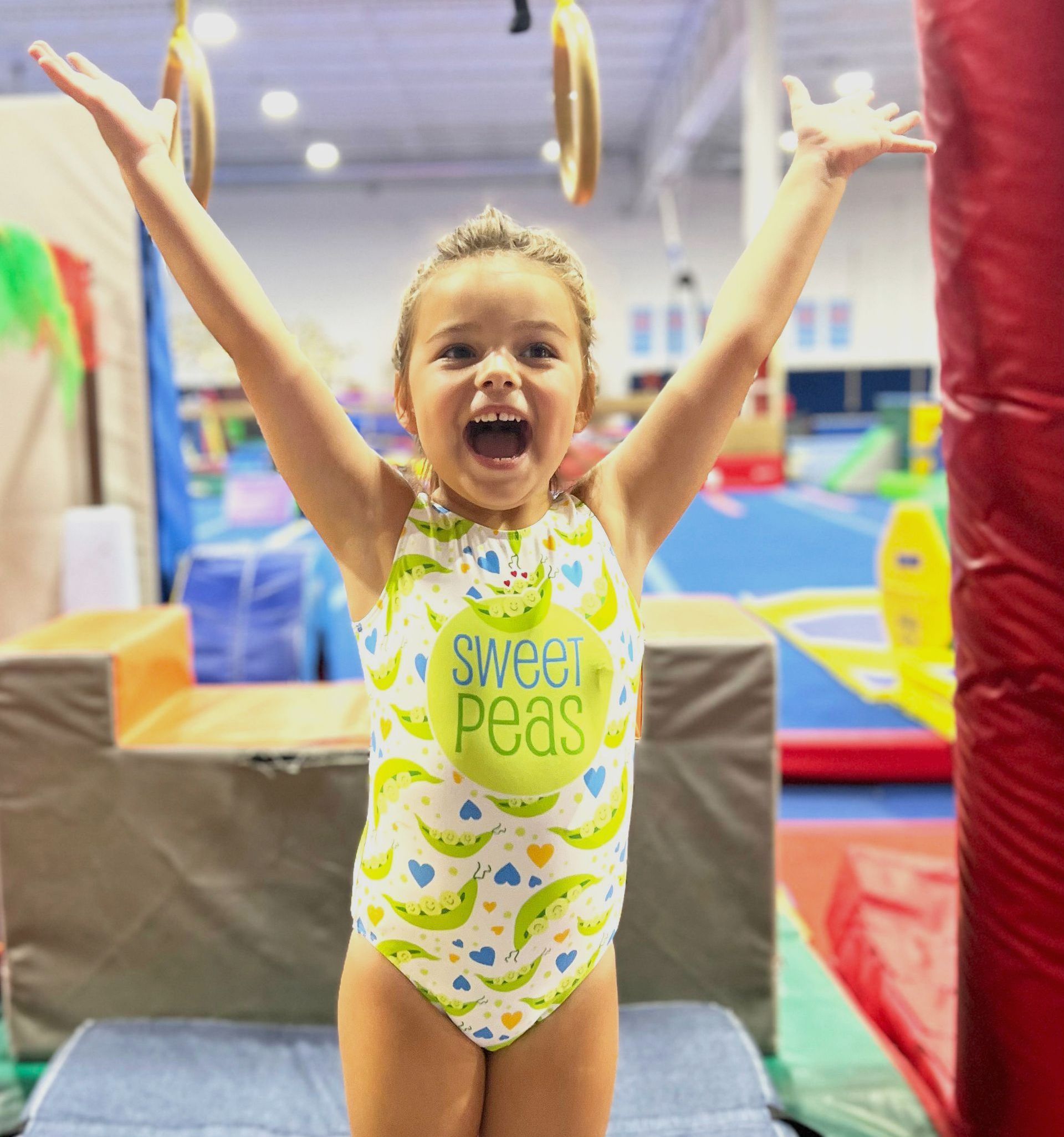 A little girl wearing a swimsuit that says sweet pea on it