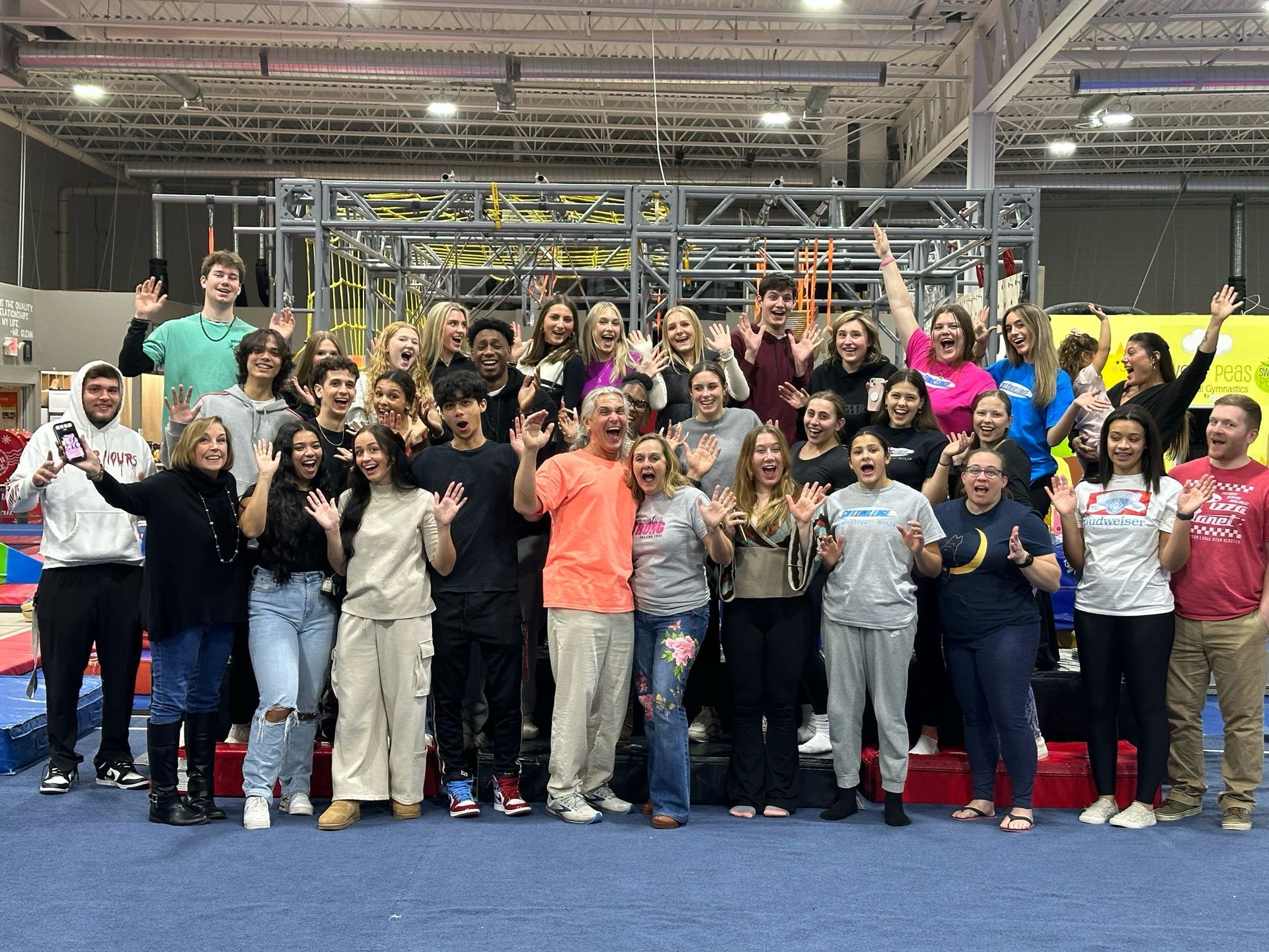 A large group of people are posing for a picture in a gym.