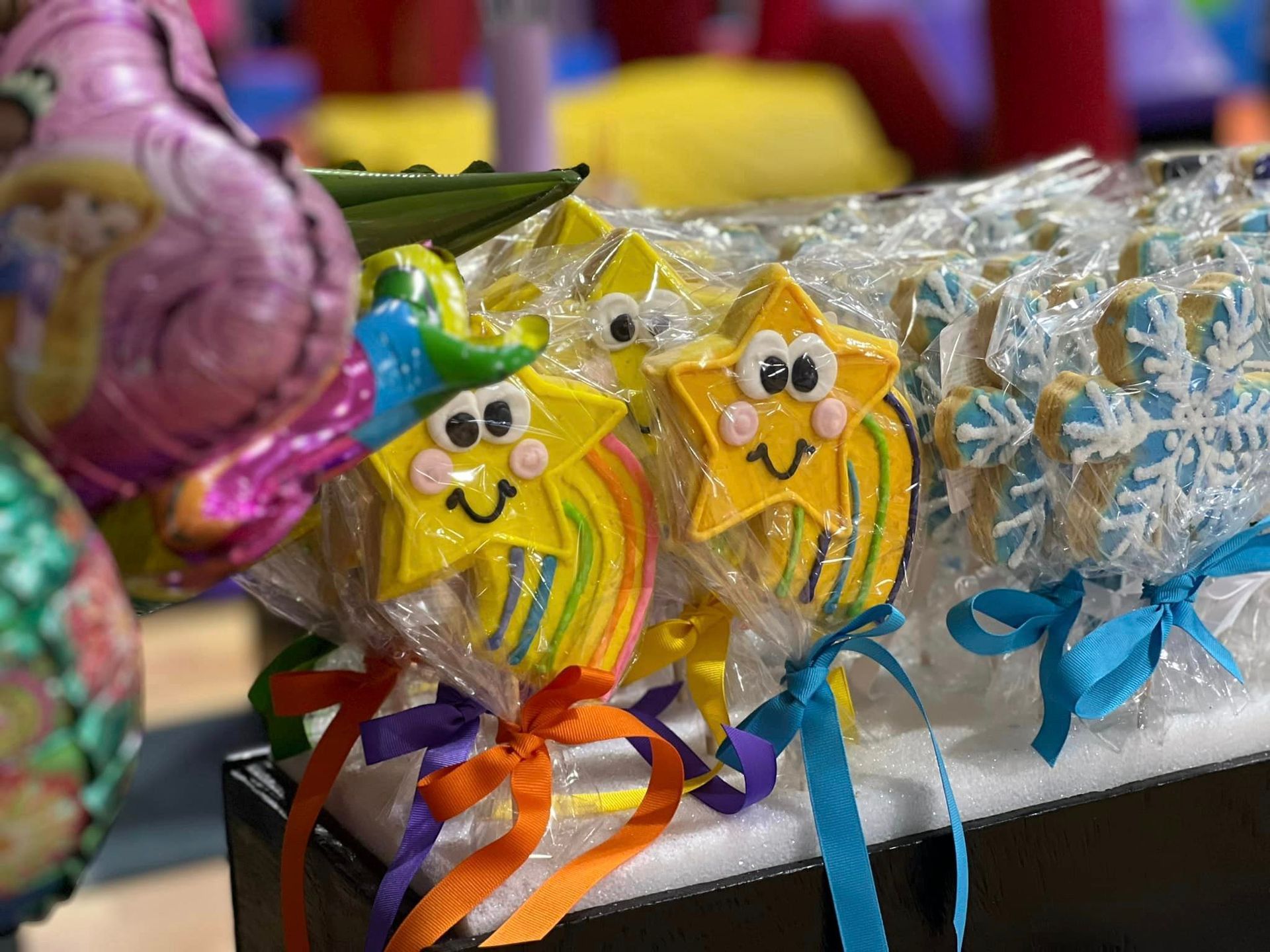 A bunch of lollipops with faces on them are sitting on a table.