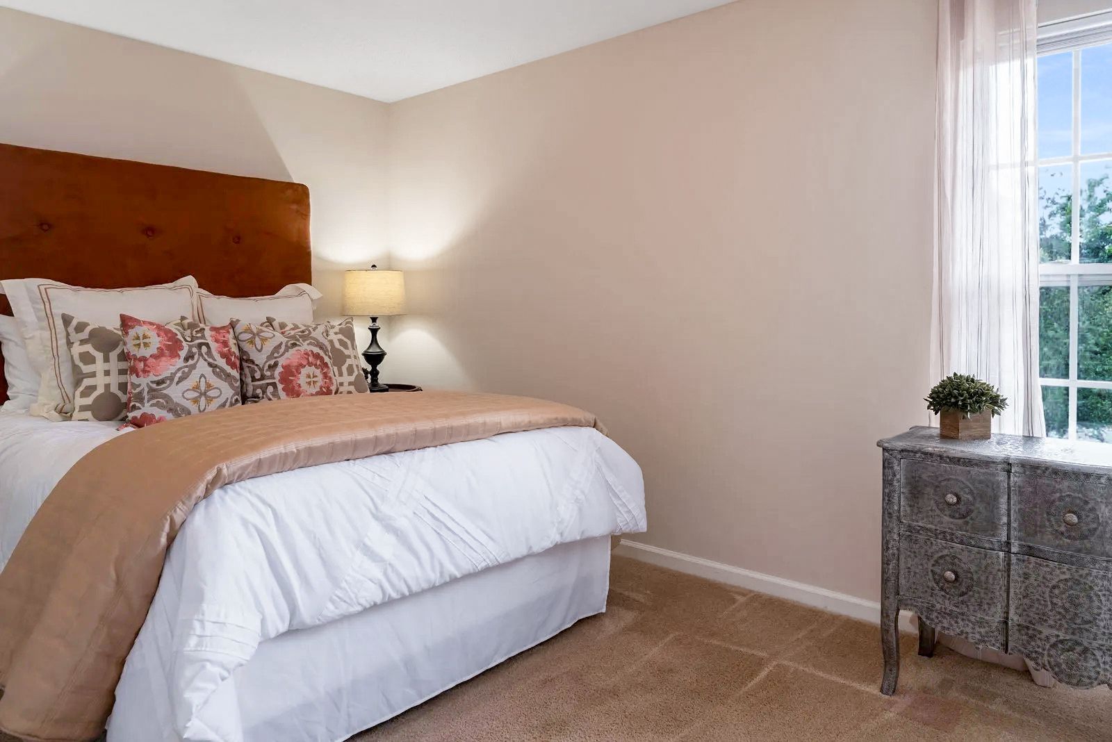 Bedroom with bed, nightstand, window, and decorative touches.